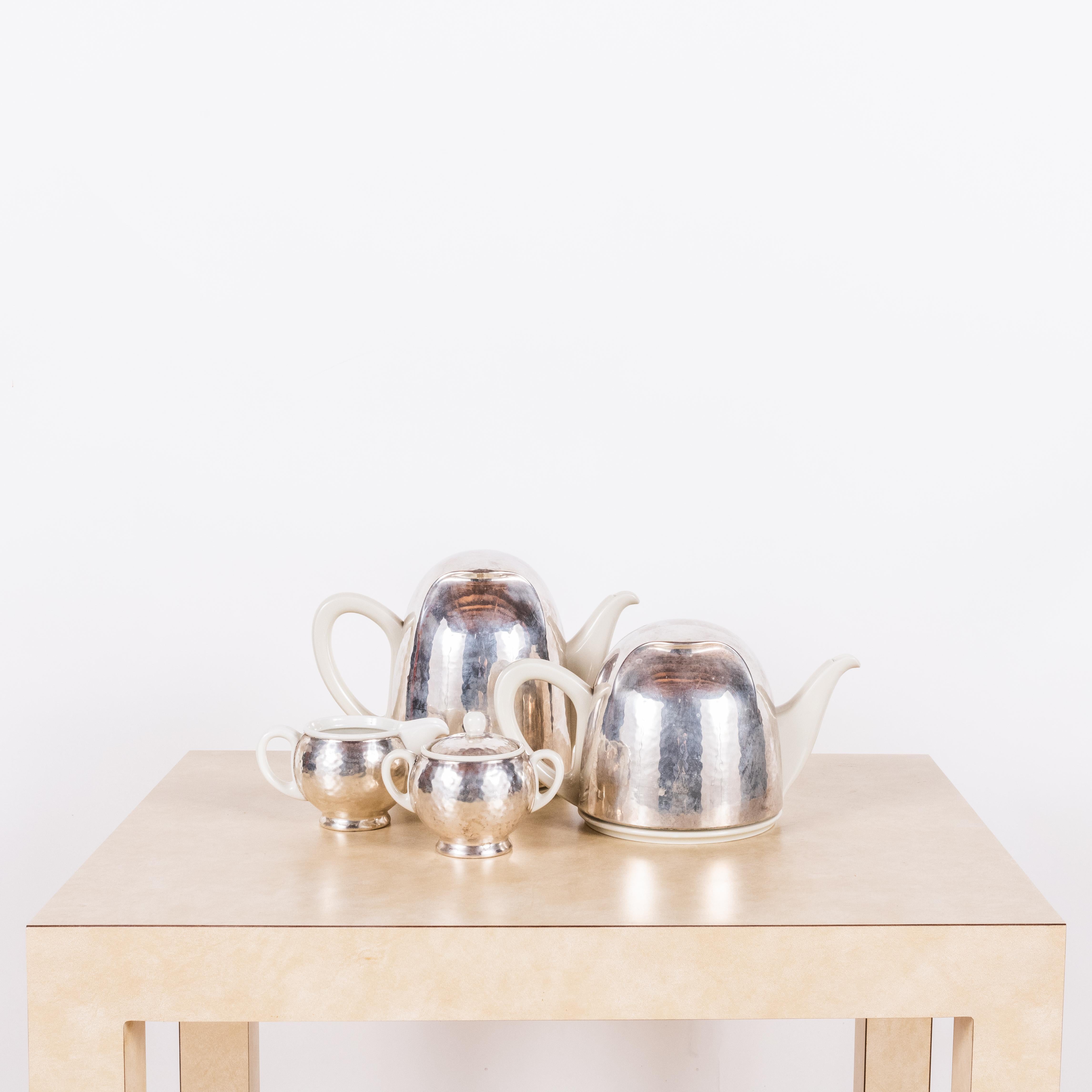 Bauhaus Hutschenreuther Selb (Bavaria) Silver-clad tea and coffee set.

Incredible design: silver plated thermal insulators lined with felt covering the pots.

Sold as a set.

Dimensions listed are for the largest piece.