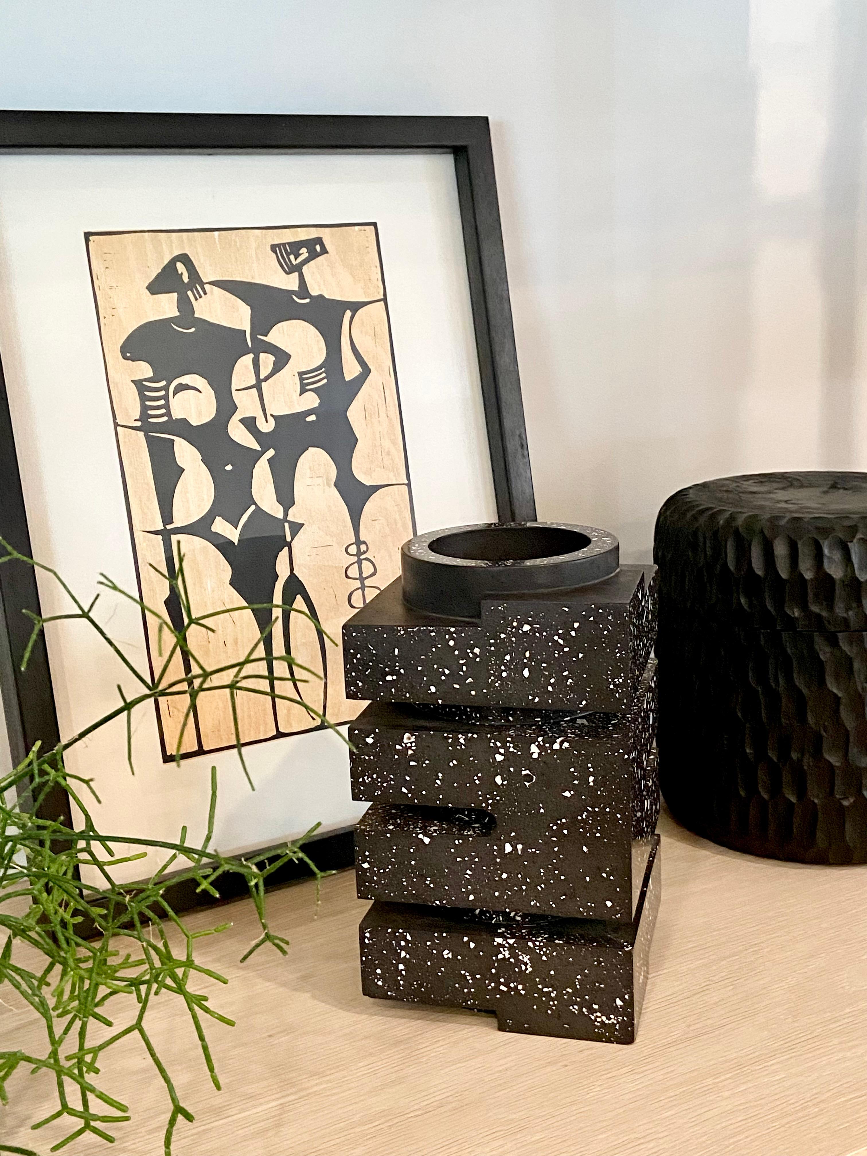 A geometrically composed black resin vase with a speckled terrazzo-like finish. Its' minimal shape is a reference to Bauhaus architecture. It's a fantastic sculptural object for a modernist interior. This vase is for decorative use only and is not