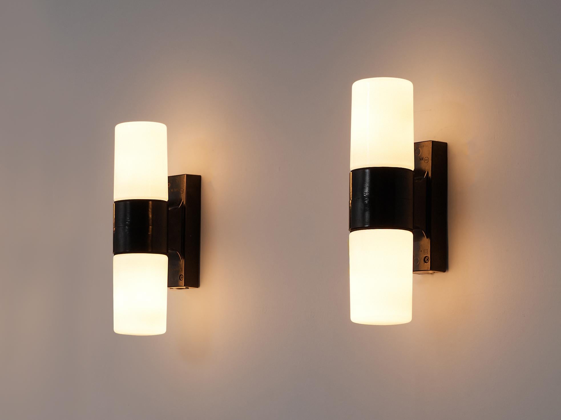ESC Zukov, wall lights model 213, Bakelite, opaline glass, Czech Republic, 1950s

Resemblance to Bauhaus architect Wilhelm Wagenfeld’s wall lamp 6040 yet these lamps differ in materials and proportions. The Bauhaus inspired wall lamps by Czech