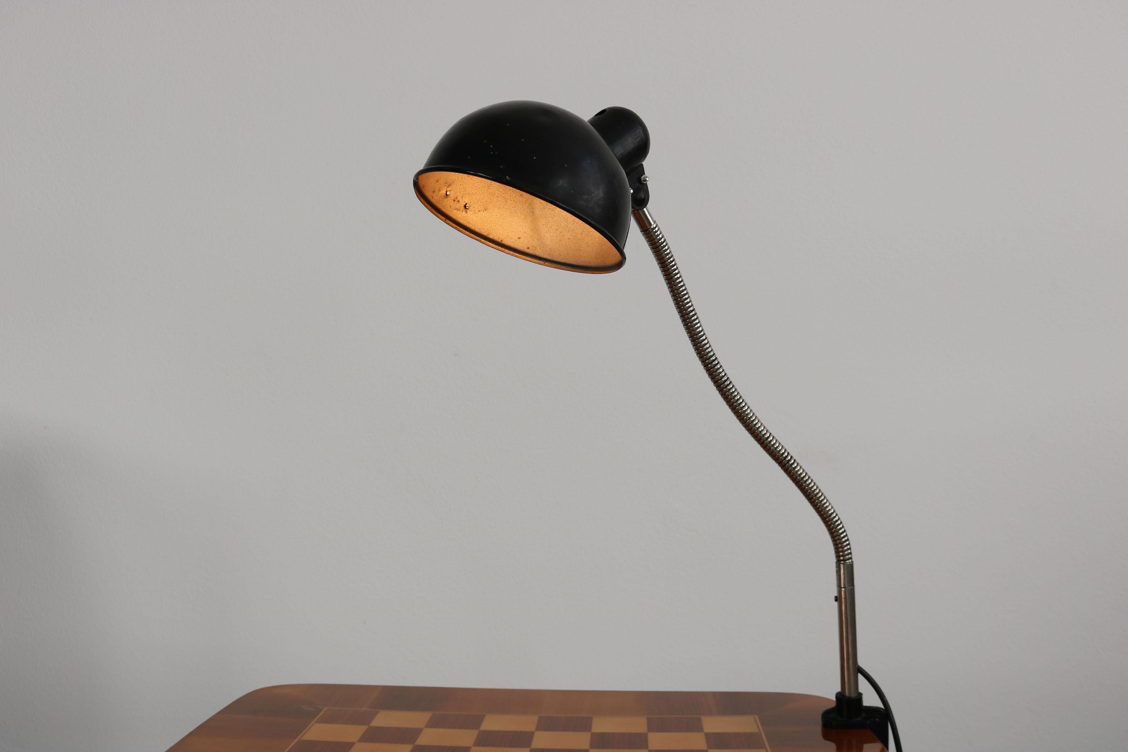 This Bauhaus lamp was designed by Christian Dell and manufactured by Kaiser Idell. It is made of lacquered aluminium and chrome-plated metal. The lamp is clamped directly to the table top. Condition: Patina due to age.