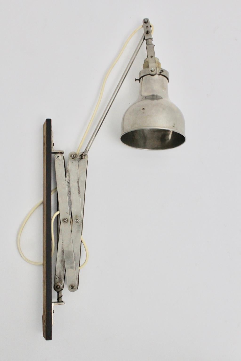 This wonderful original wall scissor Bauhaus lamp features a wall bracket made of beechwood - black lacquered.
Furthermore the wall sconce was made of metal and nickel-plated metal.
The condition is very good with signs of age and use and shows