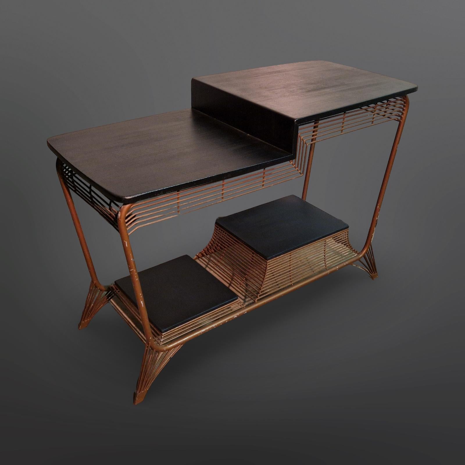Table d'appoint moderniste à plusieurs niveaux. Le cadre est en acier tubulaire avec des tiges métalliques à la fois fonctionnelles et décoratives. L'étagère supérieure est d'origine tandis que les étagères inférieures sont fabriquées en