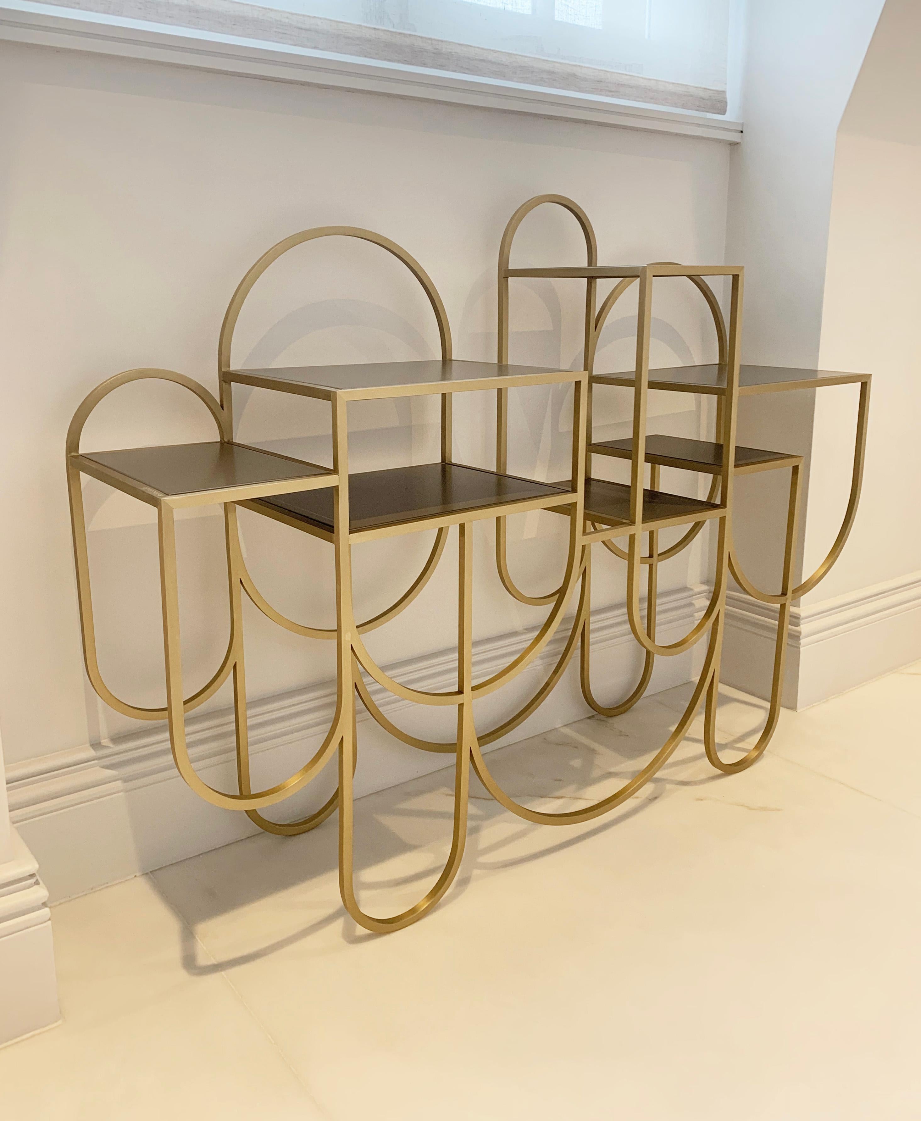 Bauhaus style gold metal console table with shelves.

This wonderful modernist style console table is by the iconic jewellery designer, turned design paragon: Lara Bohinc. This console table is like sculptural piece of jewellery ready to adorn your