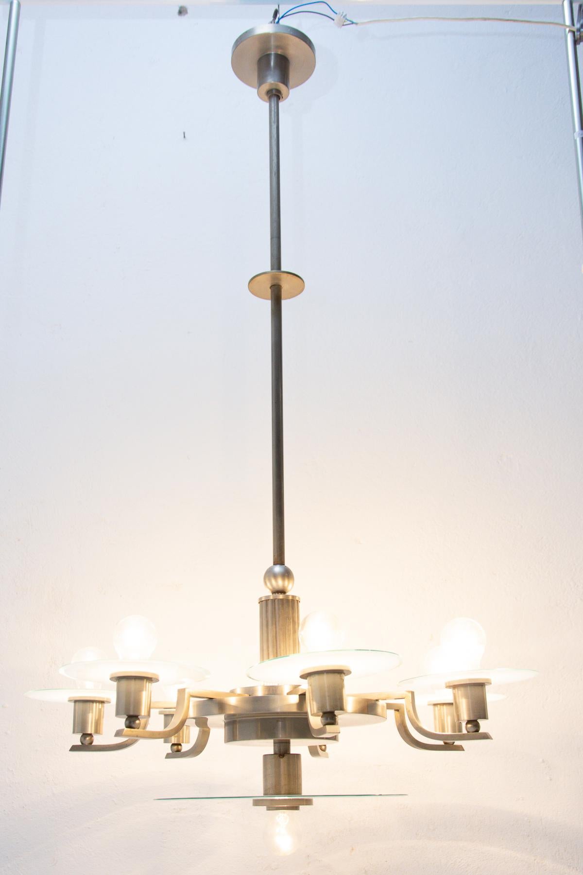 This Bauhaus nickel-plated chandelier was made in the former Czechoslovakia in the 1930´s. It has seven round glass plates.

In excellent condition. New wiring.

It has seven E14 bulbs. 250 V.