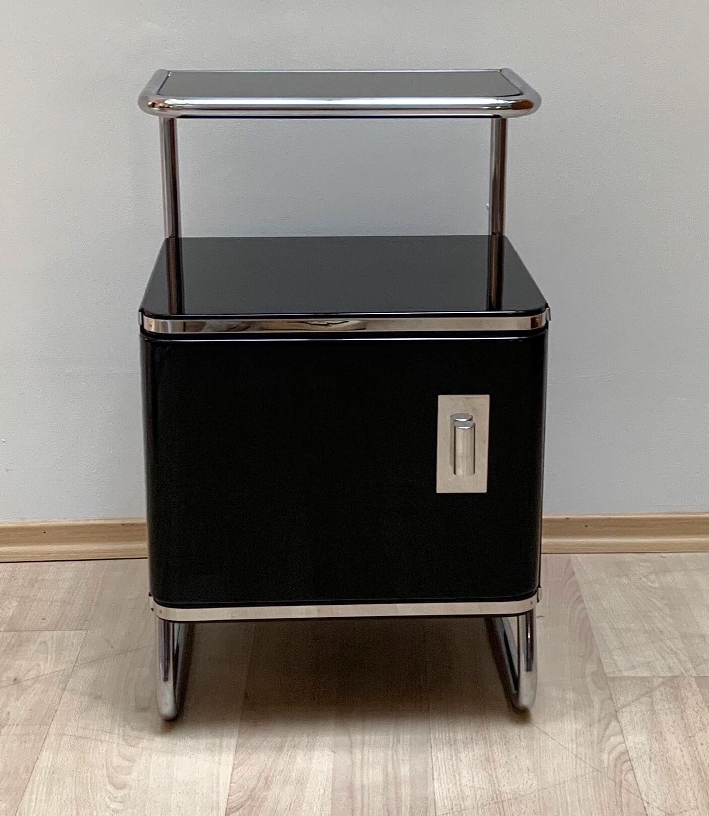 Very elegant German Bauhaus nightstand / bed side table from Germany about 1930.

(Newly) Chromed steeltube frame with black lacquered wooden box.
Black glass plate (36 x 21,5 cm) on top.

Completely restored with new black piano lacquer and newly