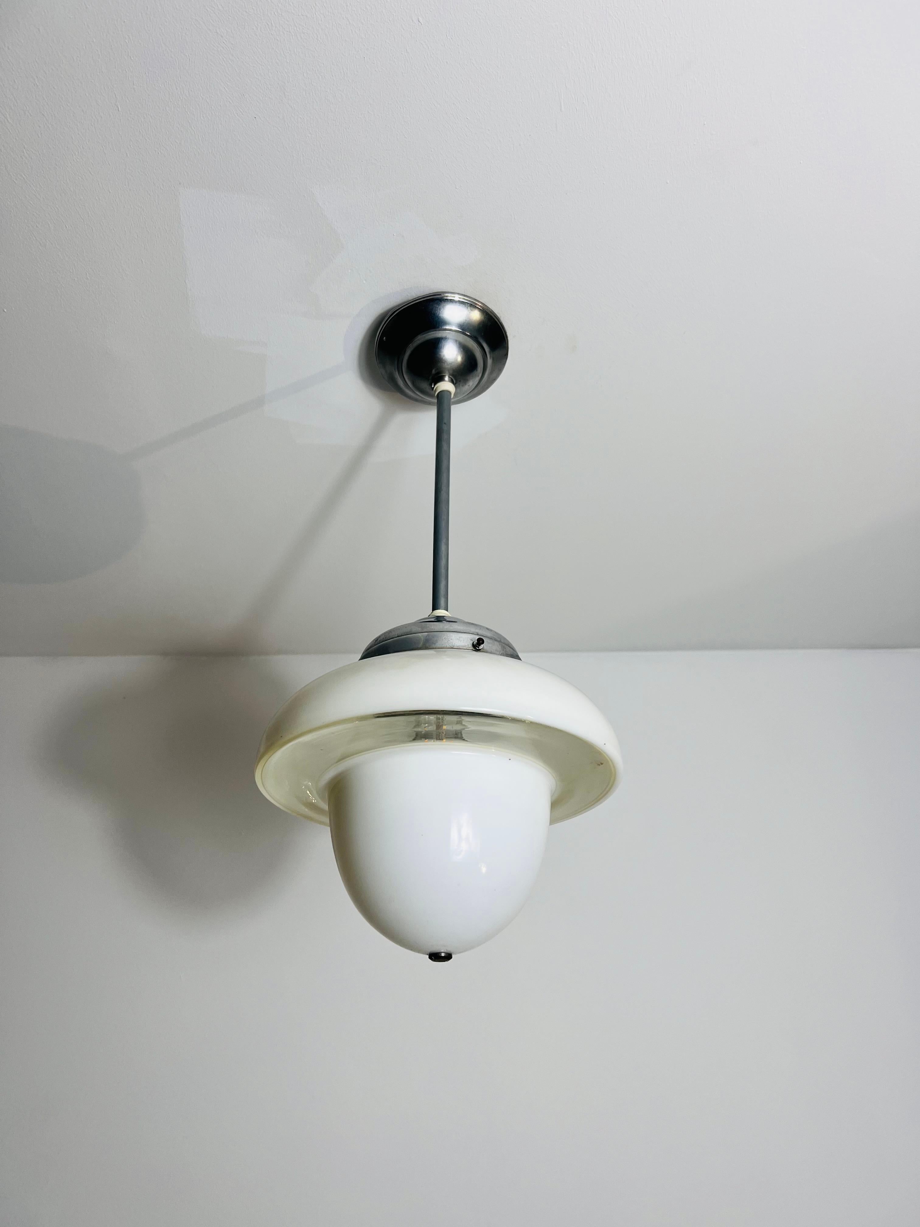 Una rara e squisita lampada a sospensione caratterizzata da una combinazione unica di vetro opalino e trasparente, realizzata in Germania. La lampada presenta un caratteristico paralume a forma di fungo, invertito per creare una silhouette