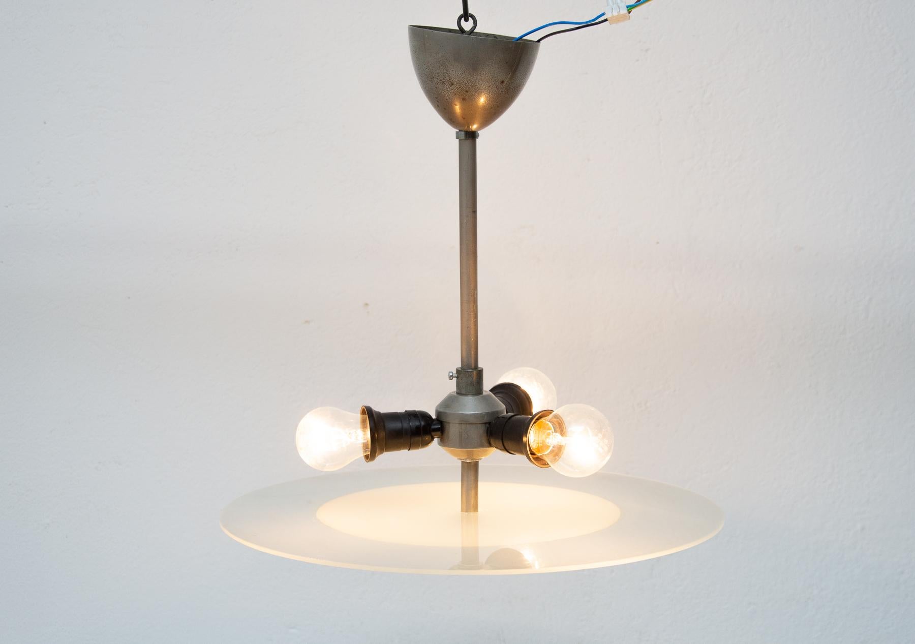 This Bauhaus pendant shaped in the plate was made in the former Czechoslovakia in the 1930s.
Made of glass and metal.
This is a typical example of Central European minimalism in the pre-war period.
The chandelier is in very good condition, chrome