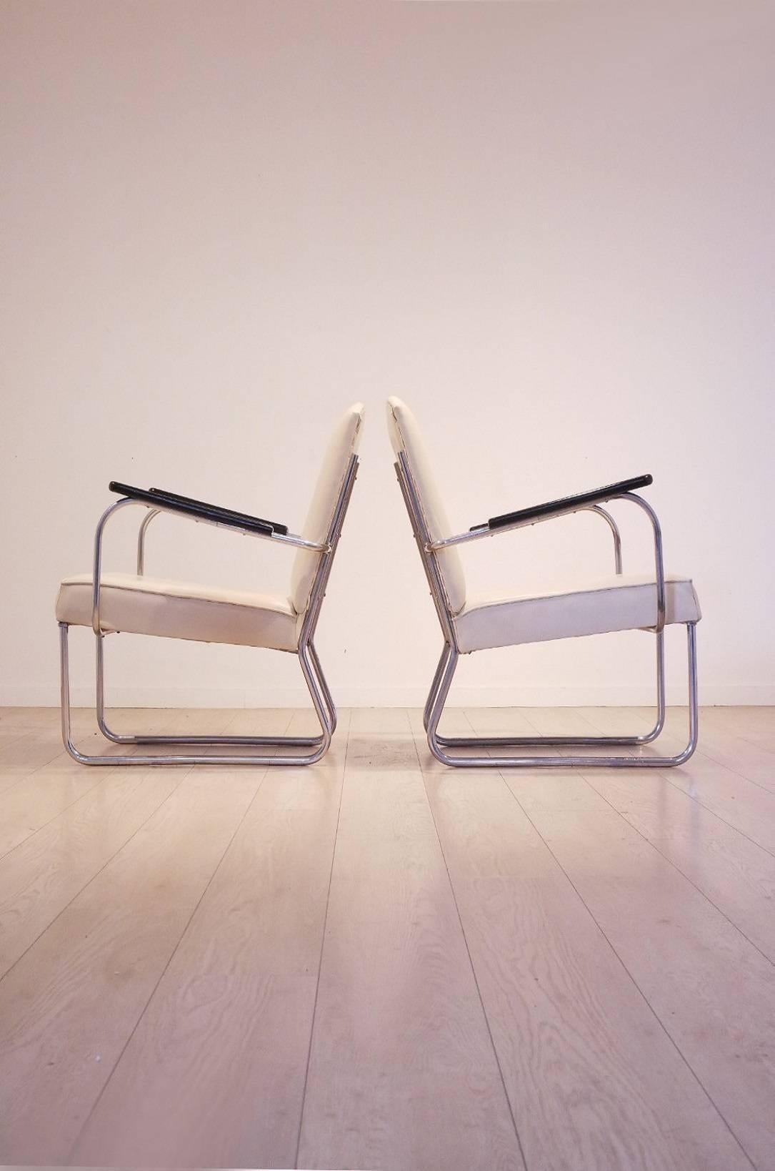 Very rare set of two Bauhaus easy chairs dating from 1935 and designed by Jan Schroefer for Circkel. Original cream colored skai upholstery matched with nickeled metal frame and black painted armrests.