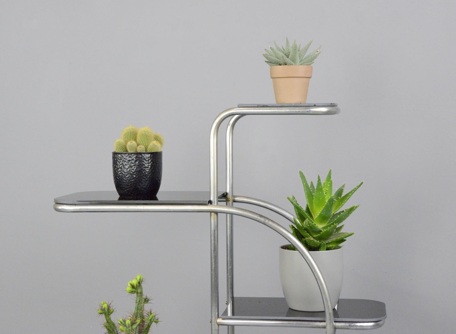 Bauhaus plant stand by Emile Guyot for Thonet, circa 1930s

- Chromed tubular steel
- Cantilever design
- Toughened black glass shelves
- Designed by Emile Guyot
- Produced by Thonet
- Czech, 1930s
- Measures: 110cm long x 27cm deep x 92cm