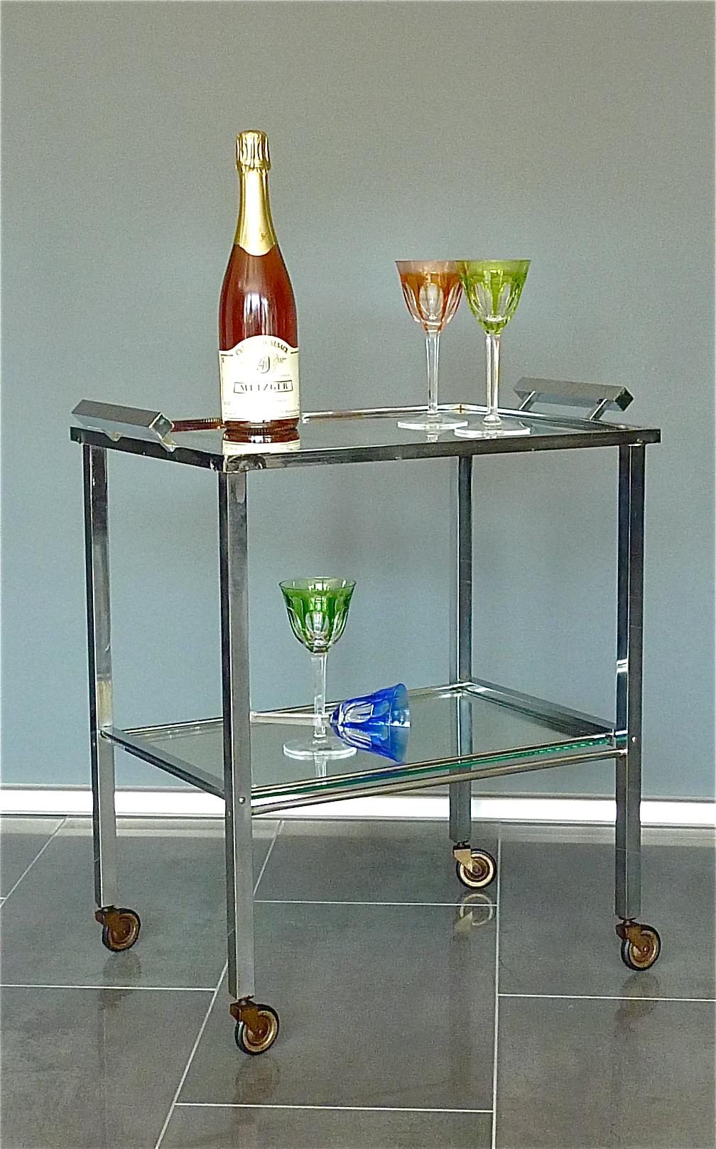 Great vintage modernist Bauhaus or Art Deco bar cart, drinks or serving table or trolley on four small wheels designed and executed in the 1920s-1930s in Germany or France. Very in the style of Jacques Adnet it is made of patinated chromed brass