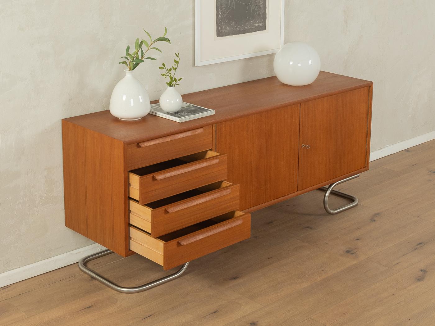 Unique sideboard from the 1960s in Scandinavian design. High-quality corpus in teak veneer with four drawers, two doors, one shelf and new stainless steel feet in Bauhaus design.

Quality Features:
very good workmanship
high-quality materials
corpus