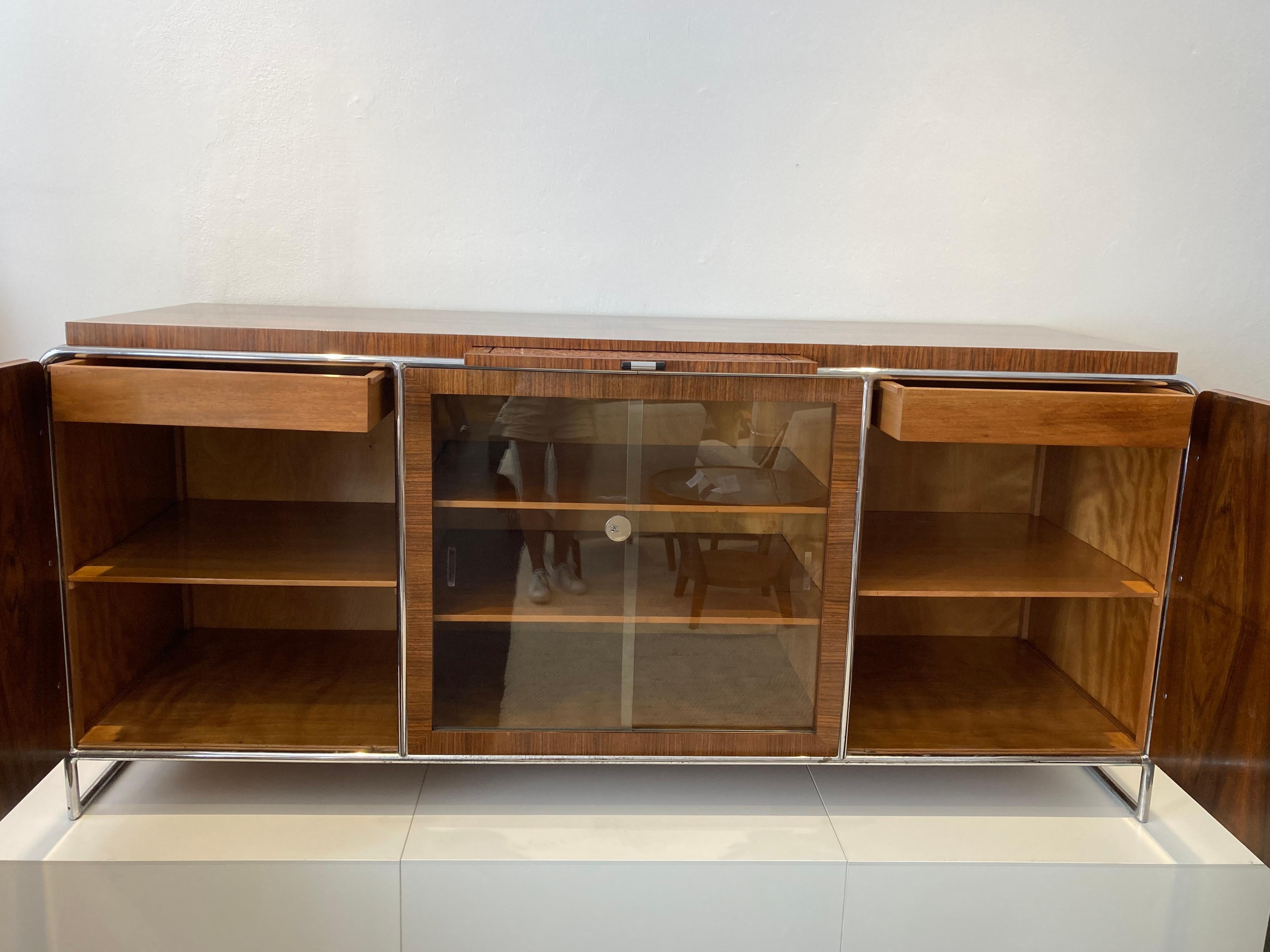 This big walnut veneered Sideboard B - 104 by H.J. Hagemann for Thonet in the 1930s has been repainted by us and the original steel tube has been polished. In the middle is the old pull-out marble slab. Original Thonet marking plate
A rarely found