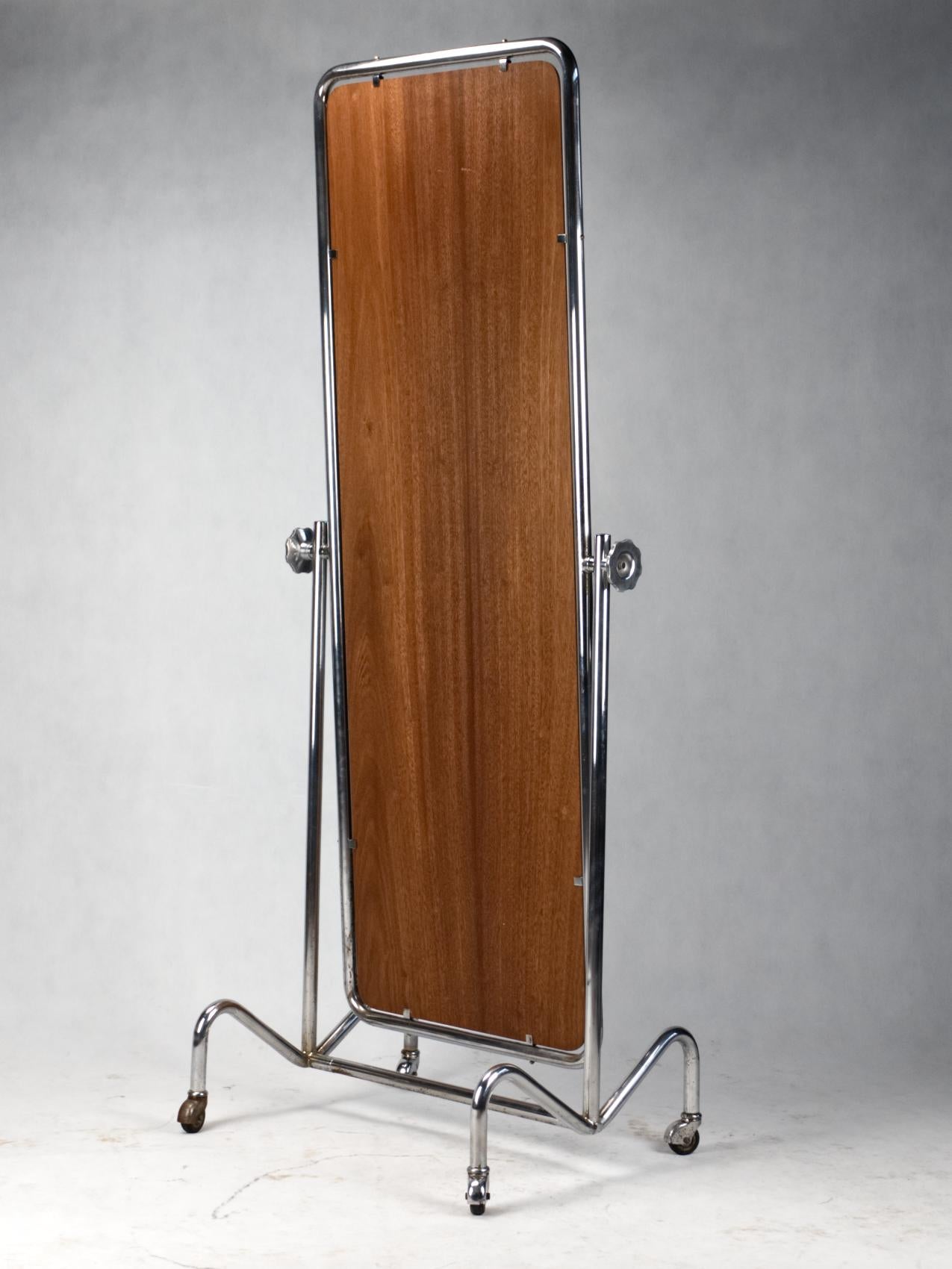 Tubular steel rolling full length mirror with rolling chrome frame, in original condition with visible wear consistent with its age and usage.
