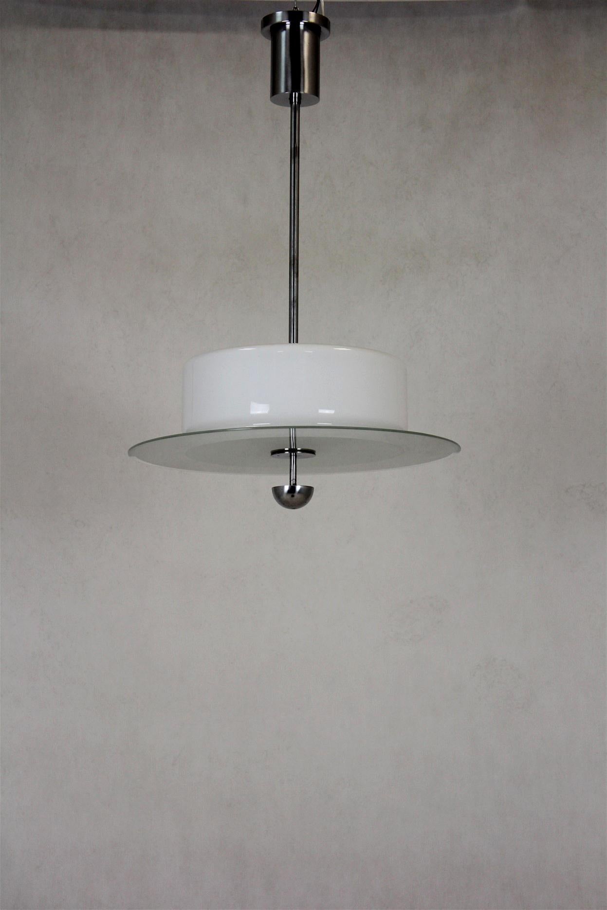 Diese Lampe im Bauhaus-Stil wurde in den 1940er Jahren in der Tschechoslowakei hergestellt. Er ist aus verchromtem Stahl und Glas gefertigt. 
Der weiße Lampenschirm hat oben einen leichten Riss, wie auf dem letzten Foto zu sehen ist.
      