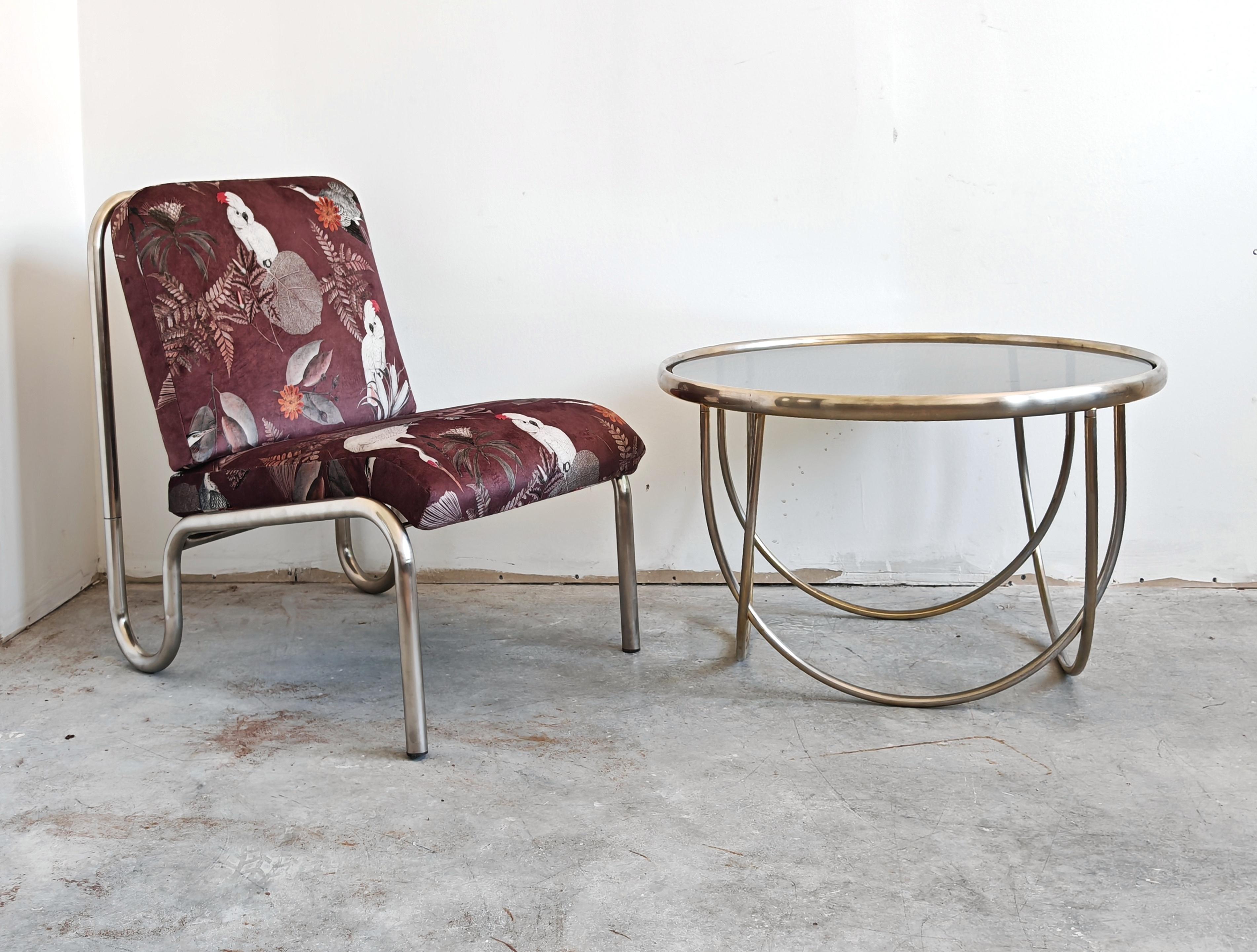 In questa inserzione troverai un tavolino da caffè in stile Bauhaus con un design unico in acciaio. Presenta gambe semicircolari e un piano rotondo, ricoperto da un vetro colorato. Realizzato in Germania negli anni '70.

Condizioni vintage molto