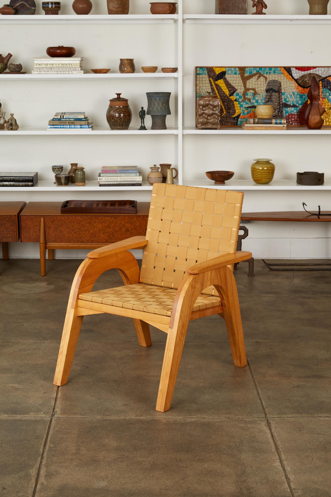 A custom studio craft lounge chair with a stylistic nod towards Klaus Grabe’s iconic pre-fab plywood furniture. Constructed in solid maple, the piece has two chunky, arched leg-pieces, topped with ovoid armrests, notched to accommodate and support