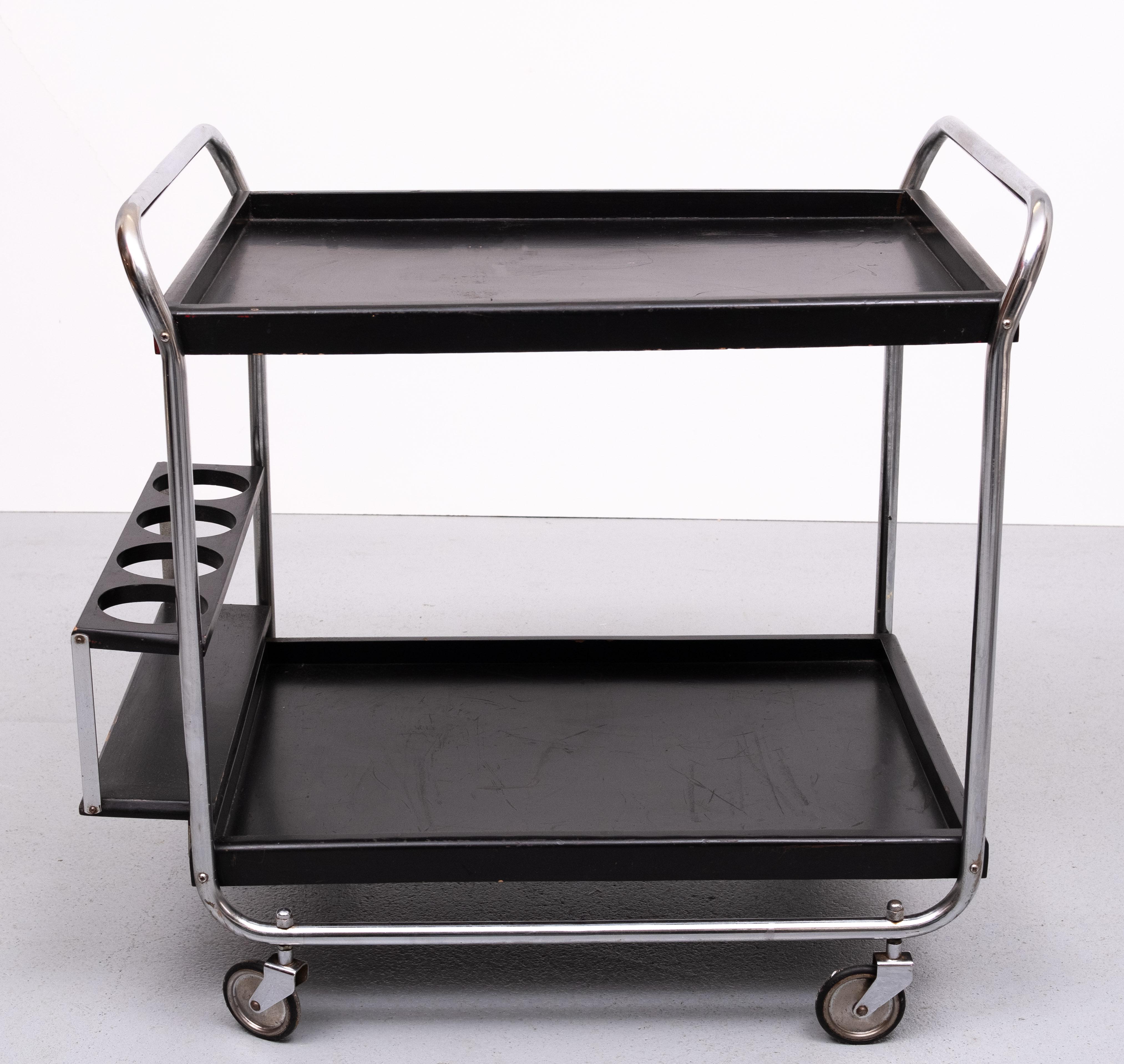 Still complete after all those years ,this Bauhaus style serving trolley .
Comes with a separated serving tray  ,very handy . on wheels .
Folding out bottle holder . Normal wear and tear  after 50 years . 