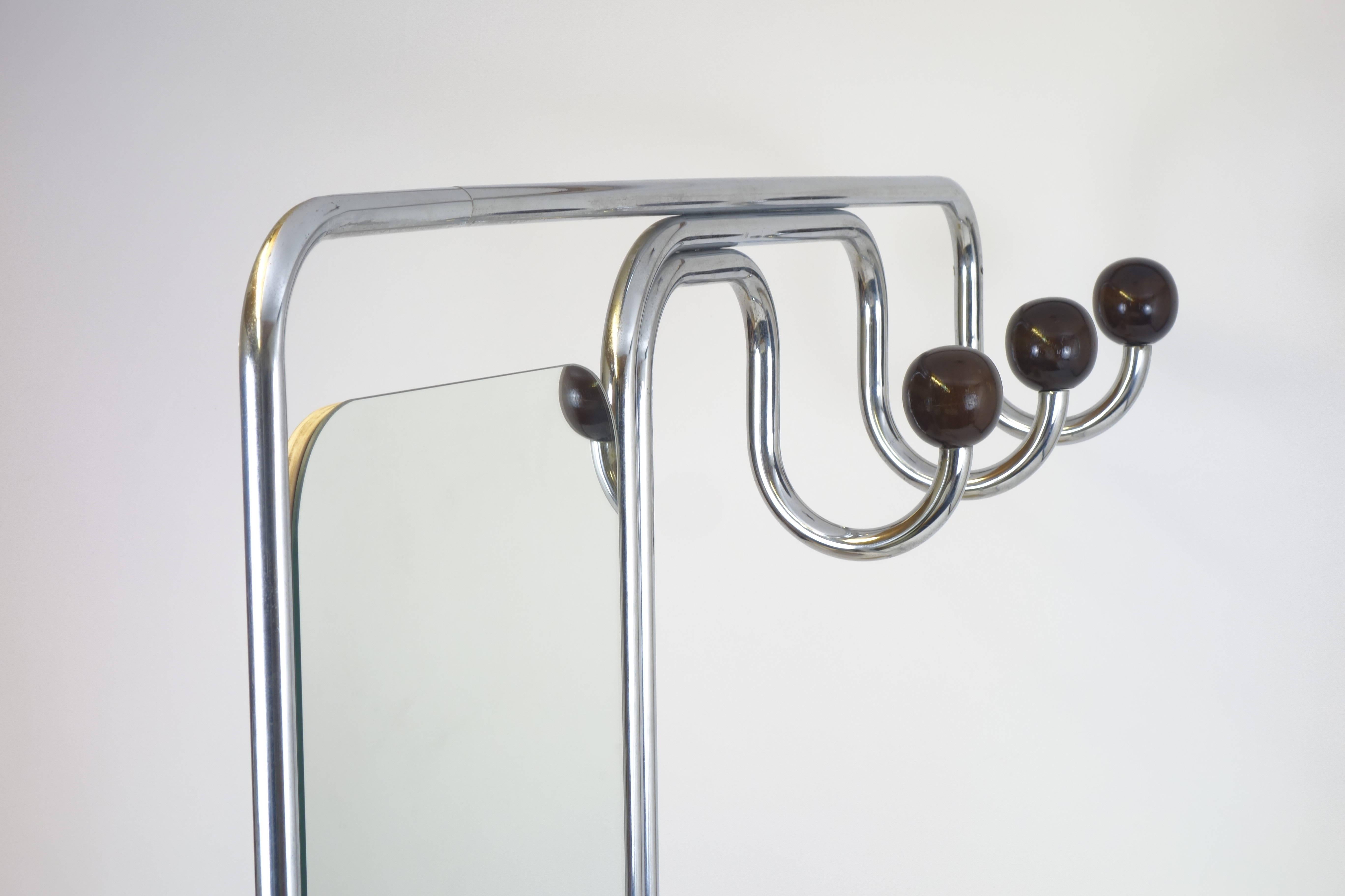 A coat and hat rack reduced to its essentials in the Bauhaus style of the 1930s. This ingeniously minimalist tubular steel concept includes 3 coat hooks with turned beechwood balls, a mirror, a shoe rack and an integrated umbrella stand. Aside from