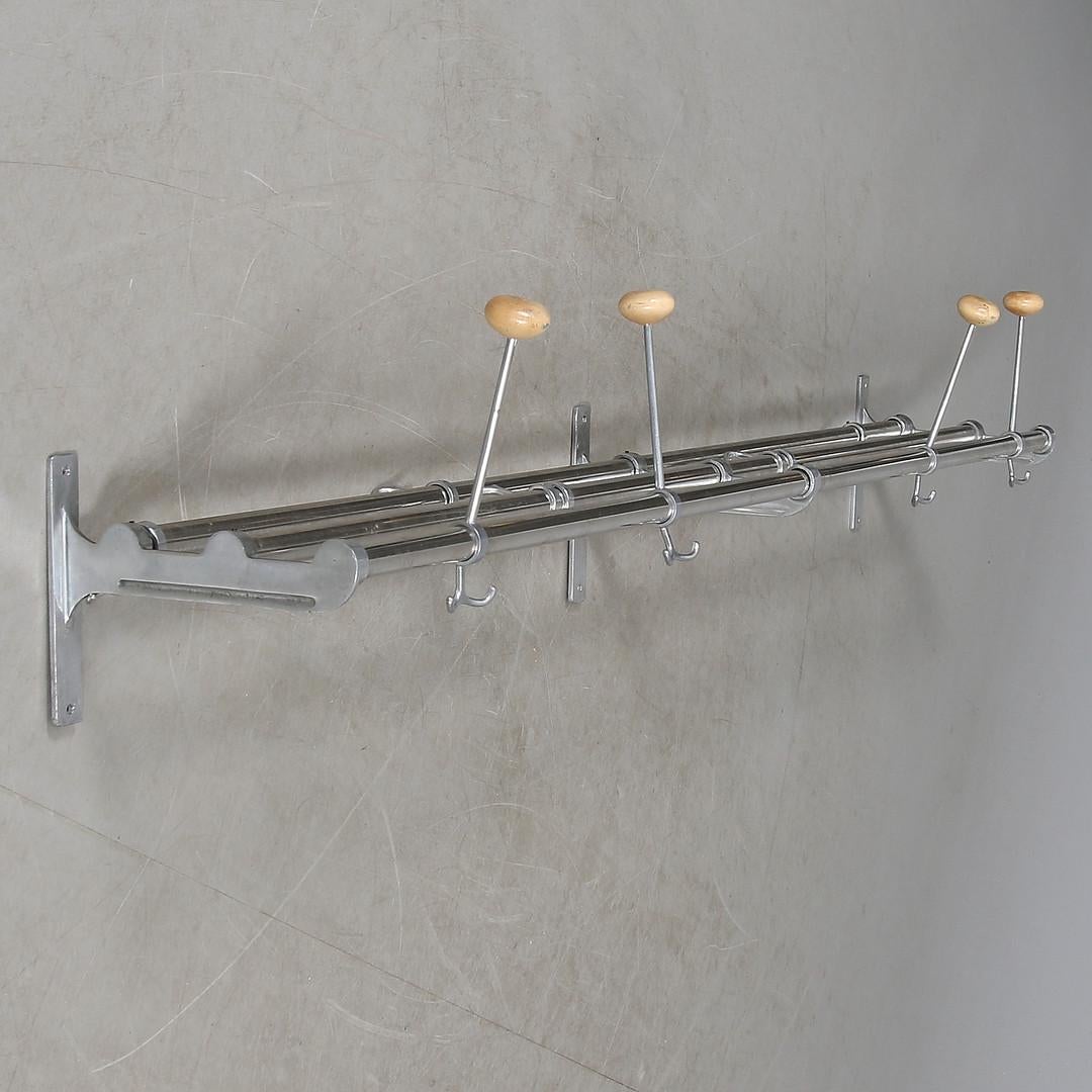 Swedish functionalistic coat rack made in the 1930-1940. Aluminum holders and hangers on beech wood bars.
The length is 150cm and it is 25cm deep.
 