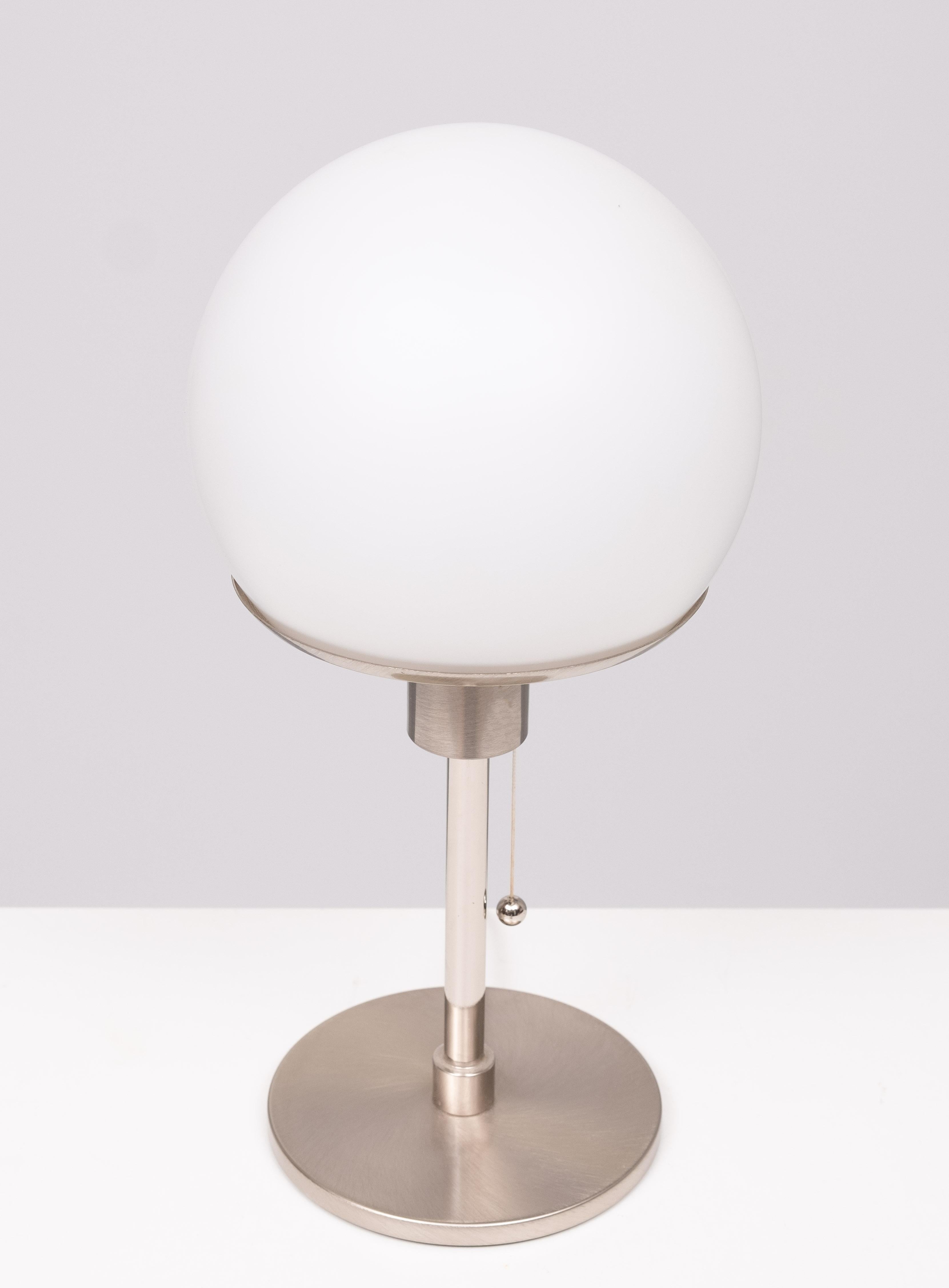 Lampada da tavolo in stile Bauhaus molto bella. Paralume in vetro opalino.
Base in alluminio lucido. Interruttore a scomparsa. Una lampadina E27 grande. 
necessaria. Prodotto da ''Post'' Lampada di buona qualità.
