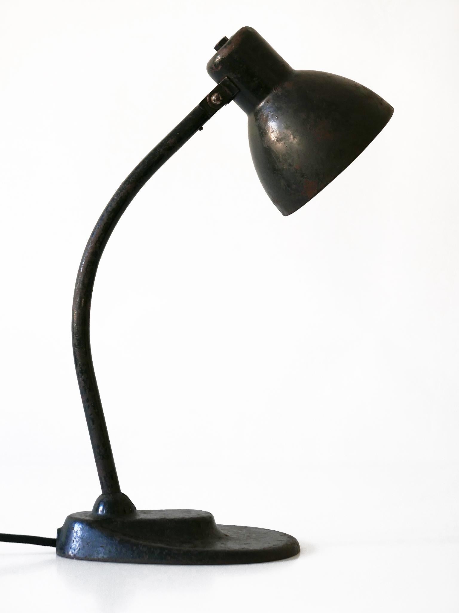 Minimalistic Bauhaus / modernist table lamp or desk light. Adjustable arm and shade. Designed by Brandt & Hin Bredendieck for Kandem (Körting & Mathiesen), 1930s, Germany. Interrupter on the lamp shade.

Executed in black enameled sheet and tubular