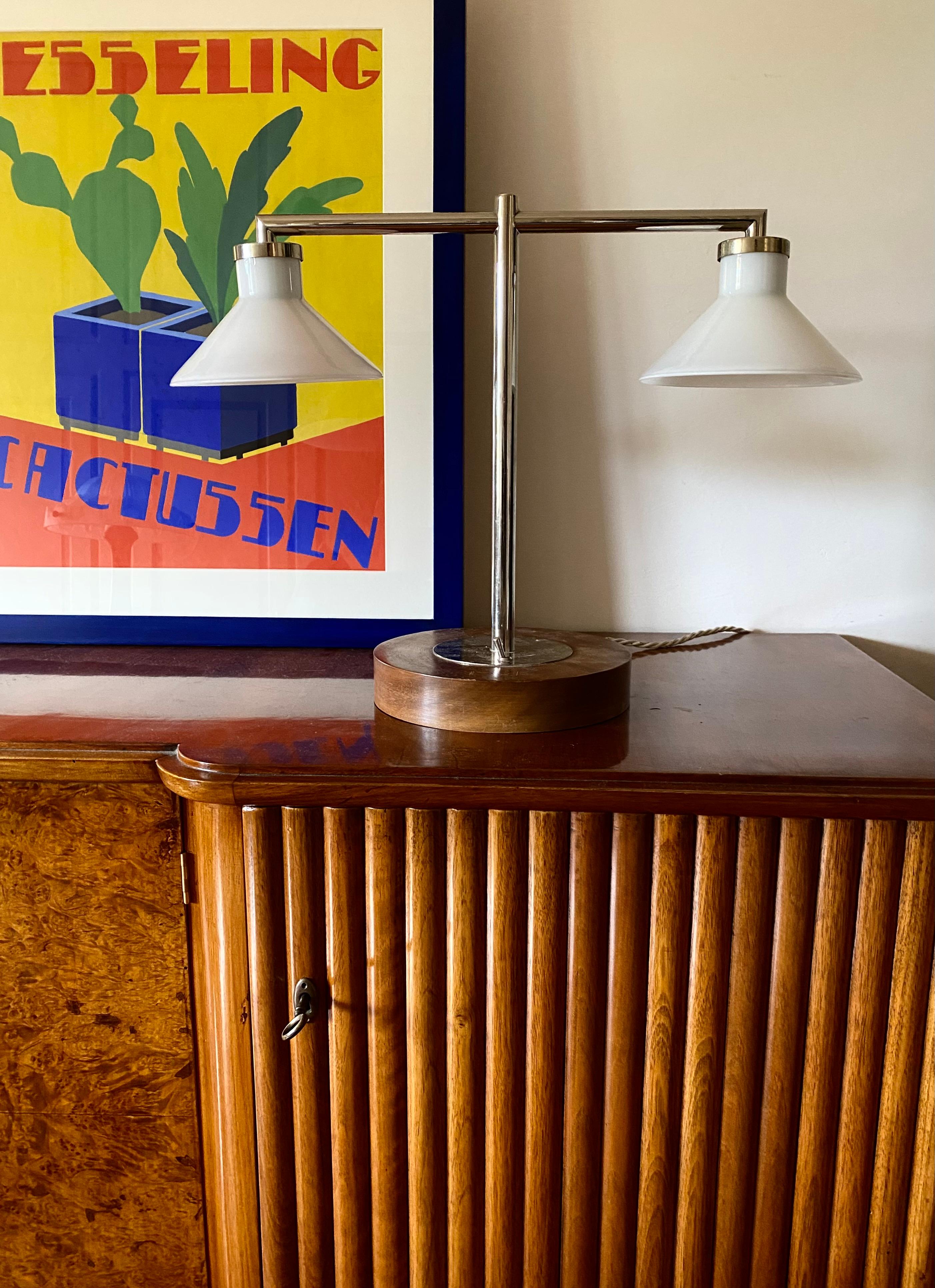 Bauhaus desk / table lamp, double arm. In the manner of Eileen Gray.

Europe 1950s

Wooden base, metal, opaline glass.

H 44 cm x W 57 cm x D 23 cm

Condition: excellent, consistent with age and use. Newly wired.