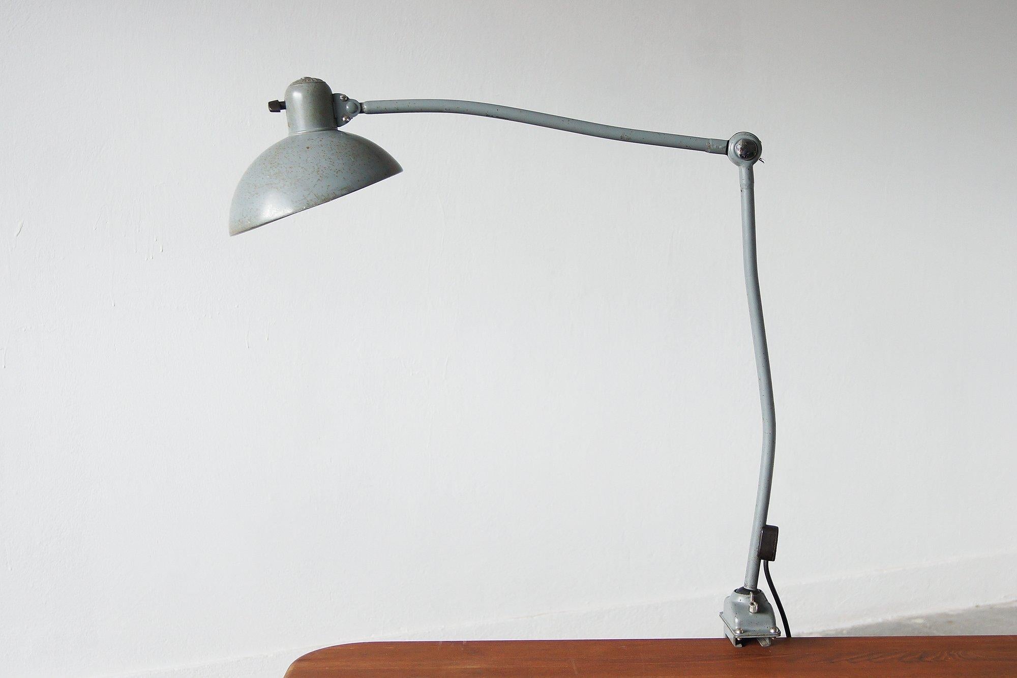 A magnificent example of this rare German classic with its domed shade and integrated Bakelite switch, patented rotating ball joints and iron clamp base.
KAISER iDELL is a series designed for Kaiser Leuchten by designer Christian Dell.
His eponymous