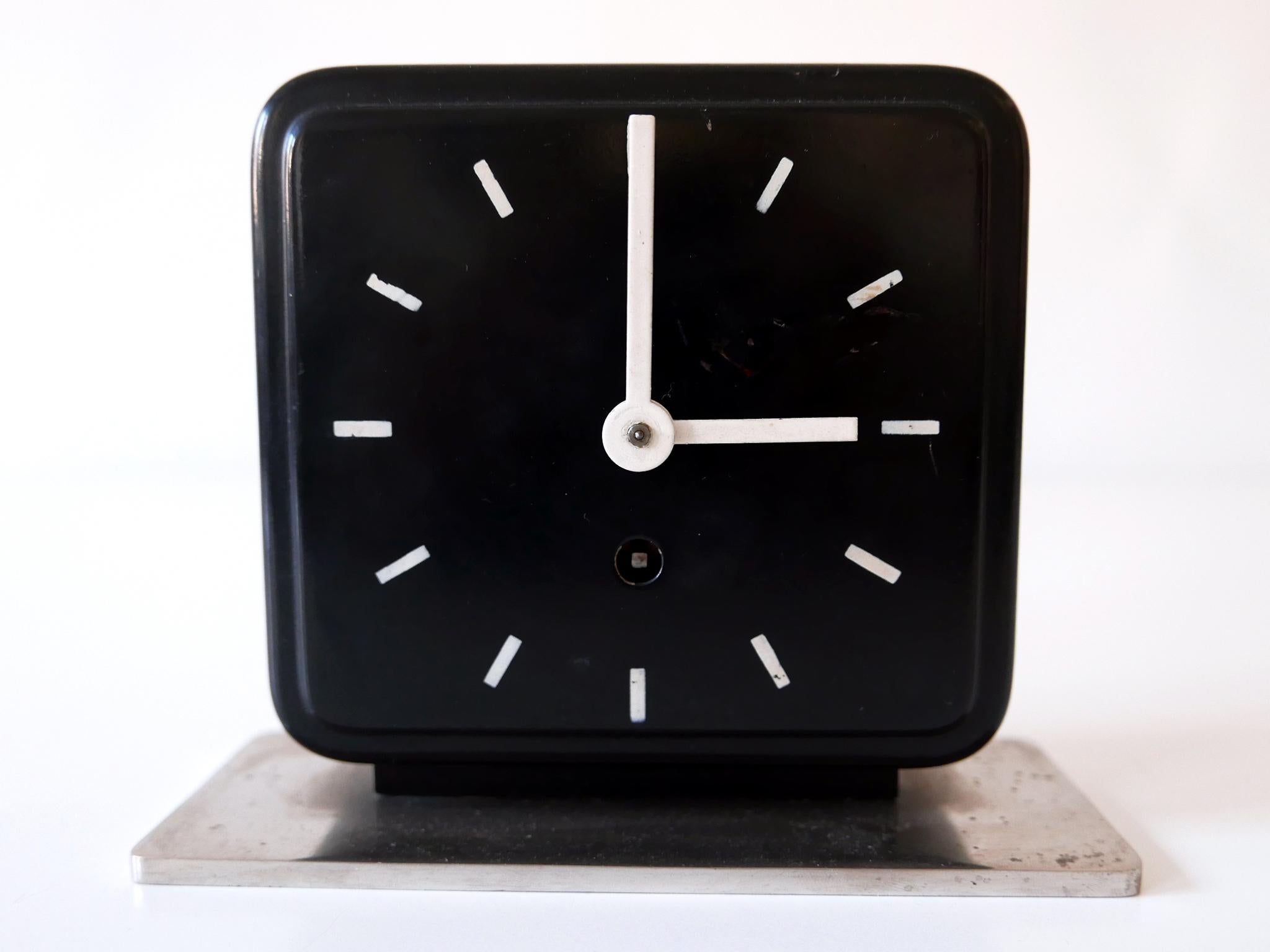 Un pur objet de design Bauhaus allemand : horloge de table ou de bureau de Marianne Brandt. Fabriqué par Ruppelwerk, Gotha, Allemagne, vers 1932. Avec horloge mécanique d'origine à 8 jours. Avec clé.

Propriété initiale de Singer Nähmaschinen