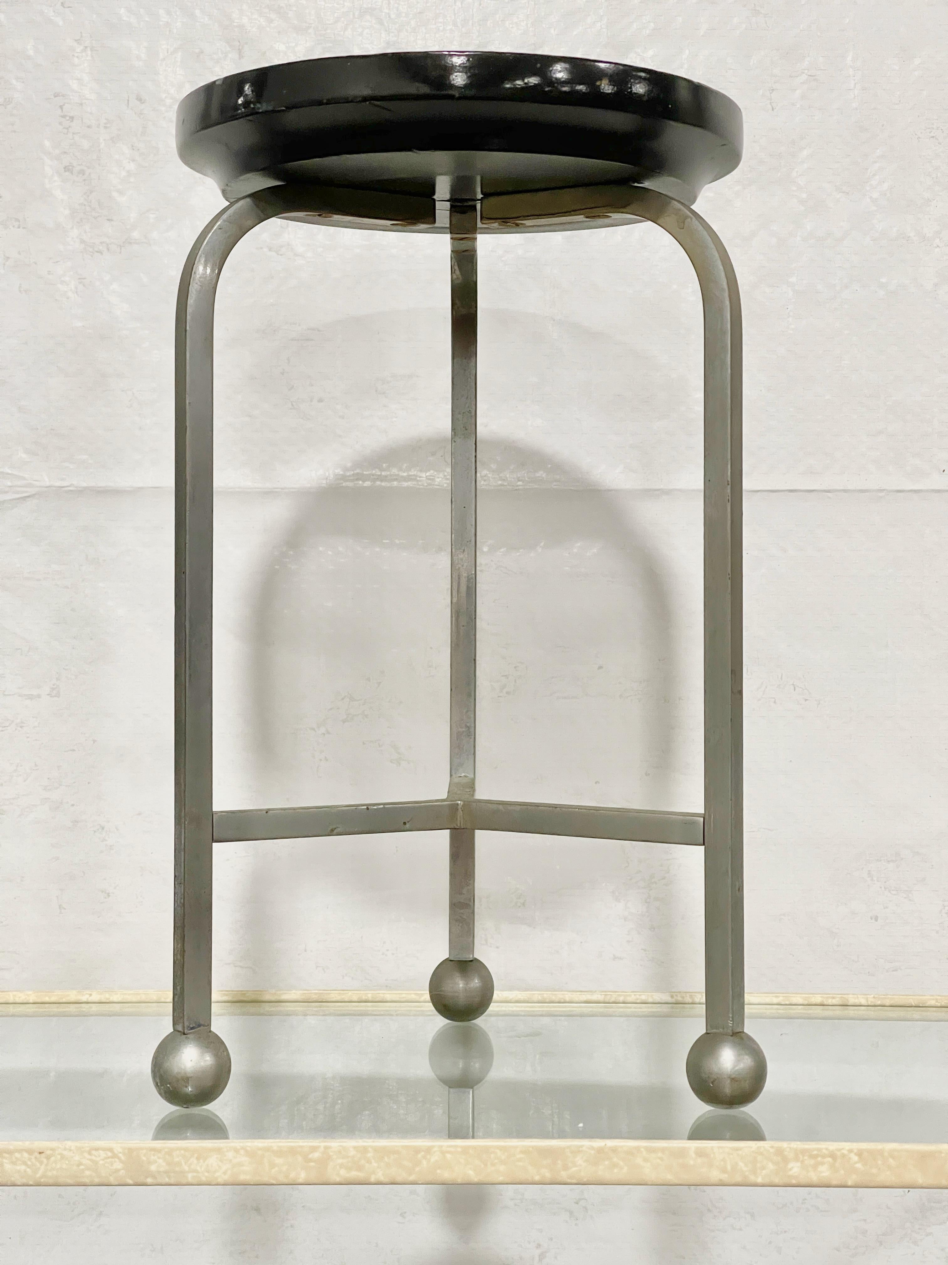 Interesting and unusual miniature Bauhaus 3-leg stool, possibly a salesman's sample or maquette. 
Round seat is black lacquered turned wood ~7.5 inches diameter by 1 inch thick. 
Three curved arc legs on ball feet with tripod stretcher stand 12
