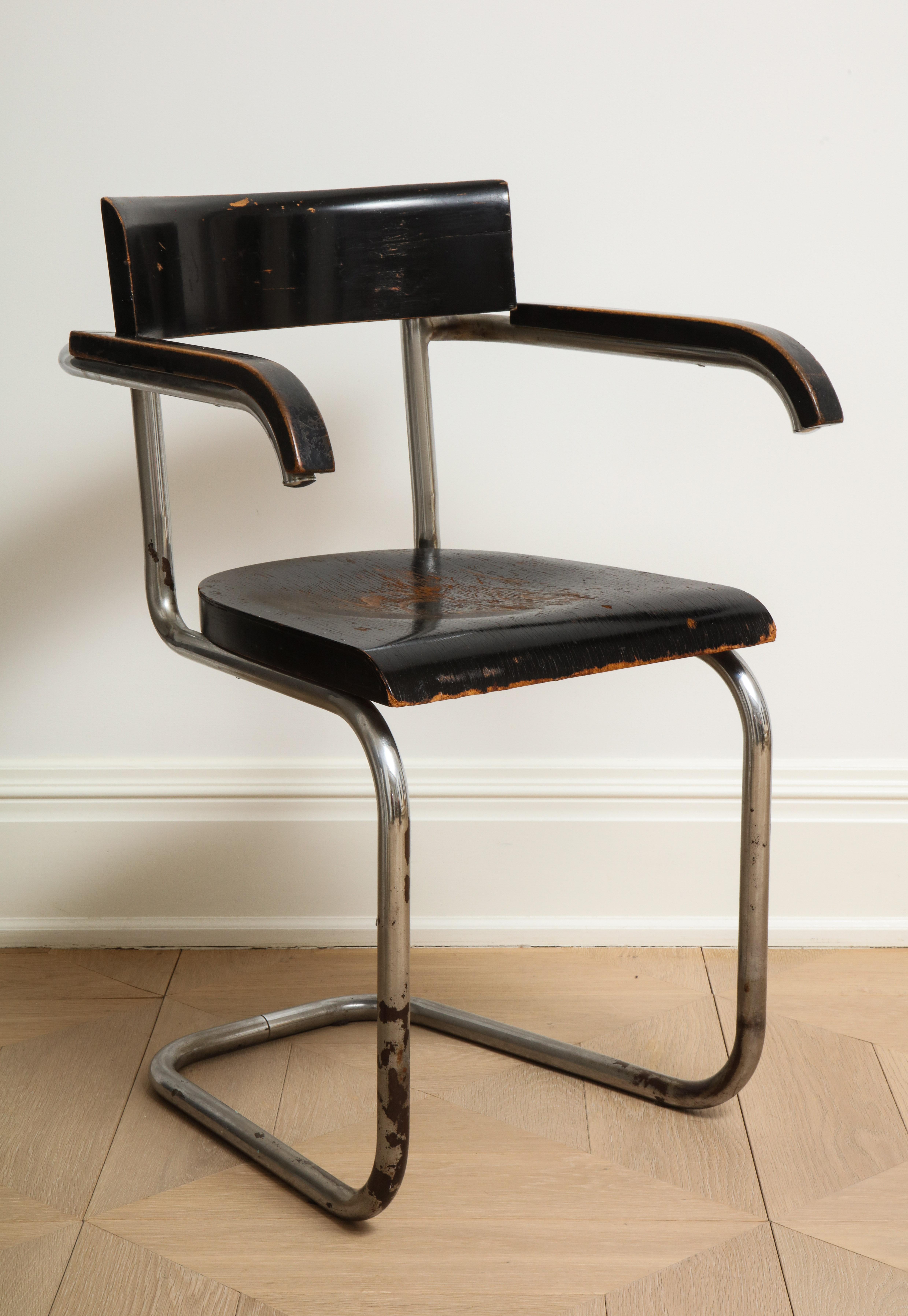 Bauhaus tubular chromed steel and ebonized beech armchair by Dutch designer Mart Stam for Thonet, 1932. The original wood finish has worn patches and there is some rust and losses in the chrome, all visible in the photos. 

Measures: Arm height