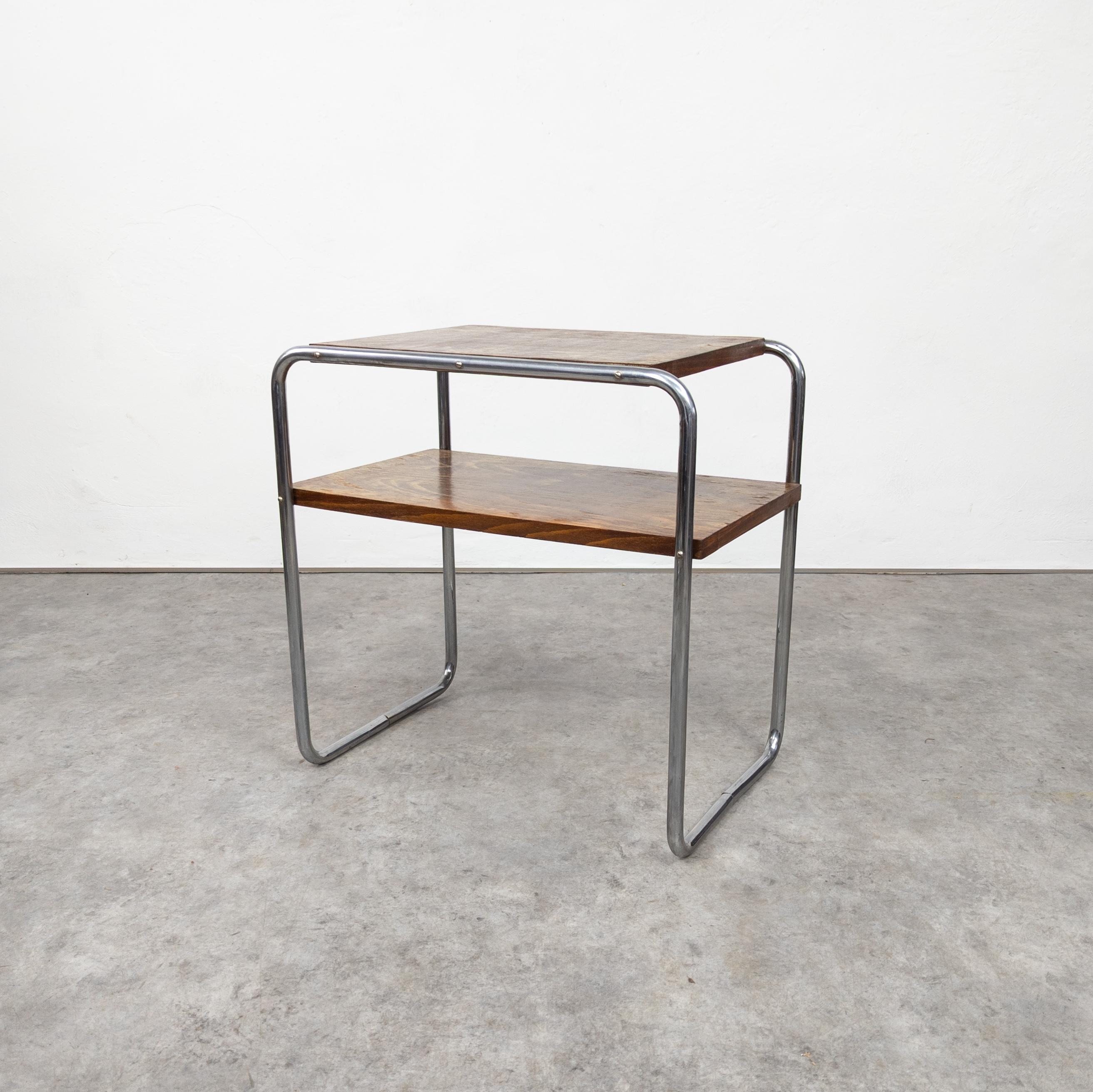 A side table with a platform stretcher, Model No. B 12, designed by Marcel Breuer in 1928,
manufactured under a Thonet licence by Robert Slezak c. 1930, chromium plated tubular steel construction, walnut veneered blockboard. 

Very good original