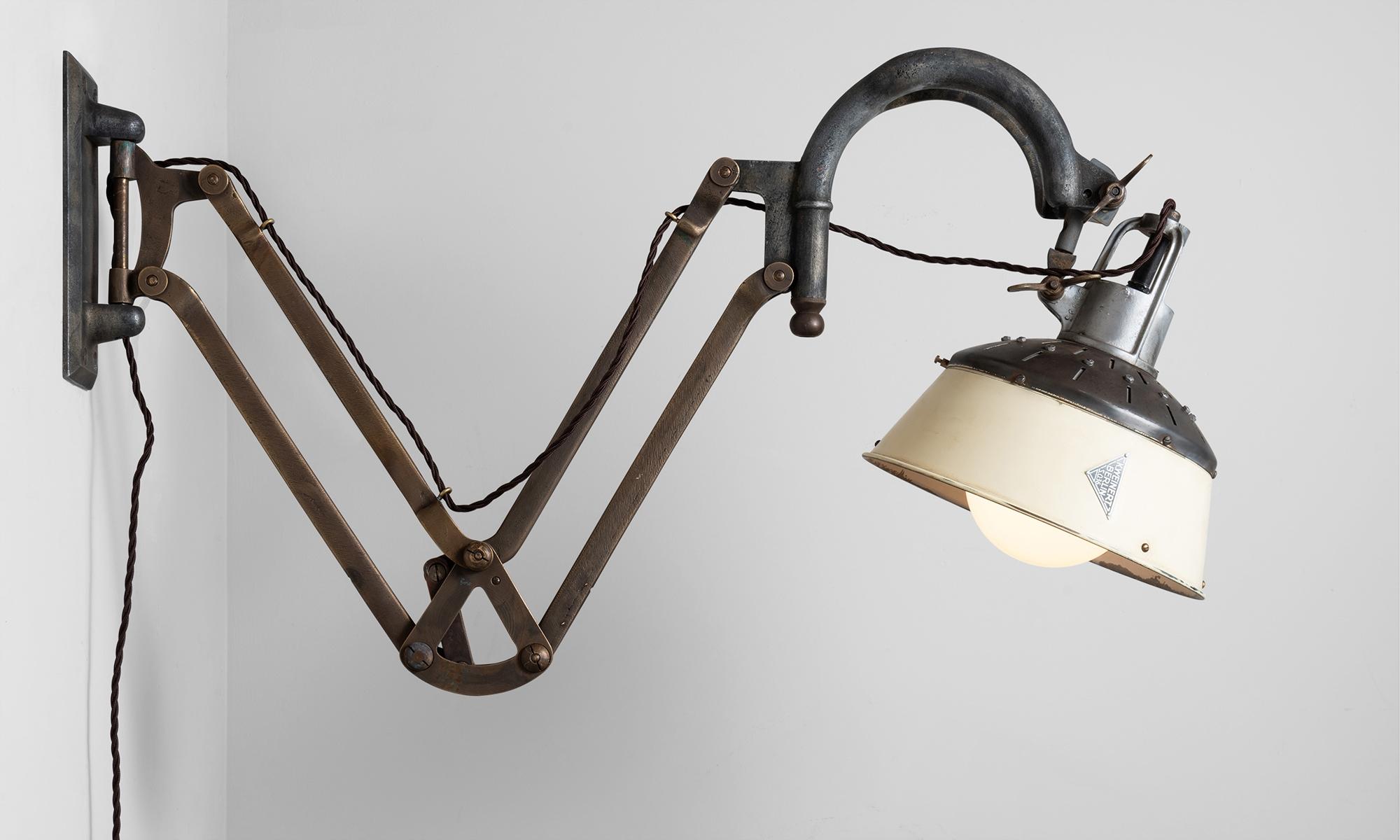Unique wall lamp with brass and steel arm that pivots side to side as well as up and down. Lamp shade has original K. Weinert makers mark, and internal mercury glass refelctory.