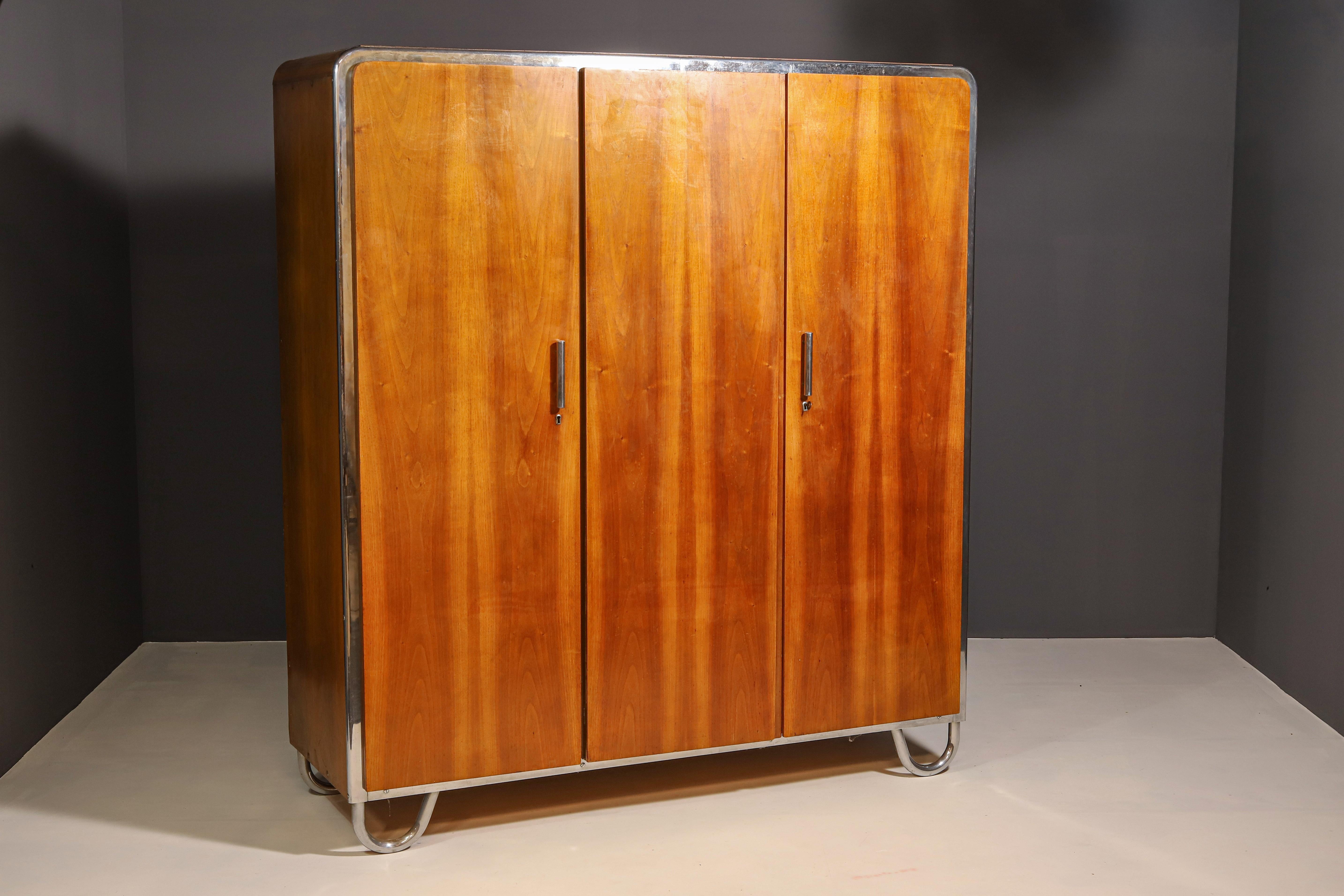 Armadio con elementi cromati del periodo Bauhaus. È stato realizzato nell'ex Cecoslovacchia. Progettato e prodotto dall'azienda Slezák negli anni '30, l'etichetta di produzione si trova all'interno del mobile sulla porta.
Si tratta di un tipico