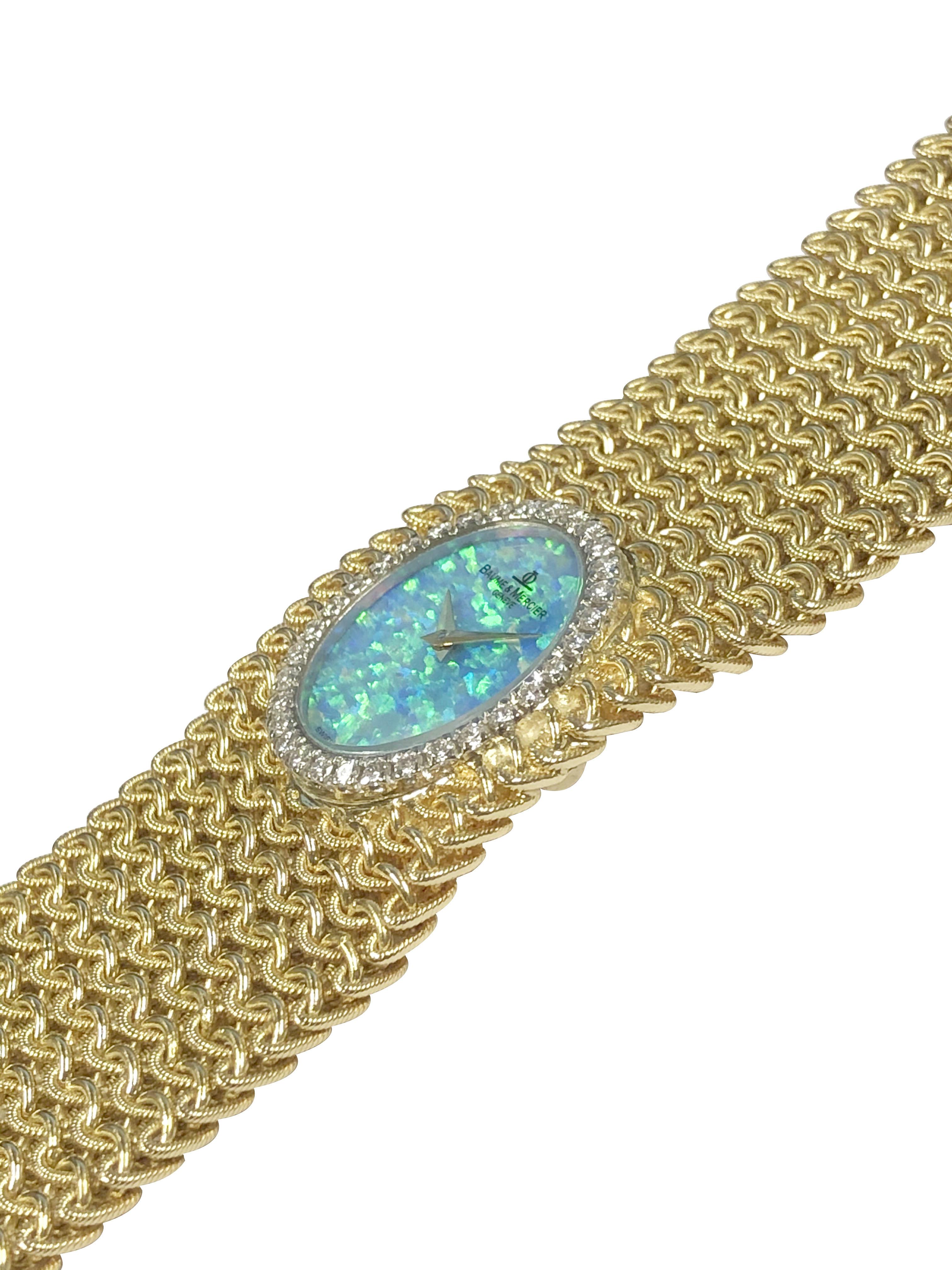 Circa 1970s Baum & Mercier Ladies 18K Yellow Gold Bracelet Wrist watch, a soft and flexible mesh link textured bracelet measuring 7 inches in length and 1 3/16 inch wide. White Gold Bezel set with Round Brilliant cut Diamonds totaling 1 Carat. 