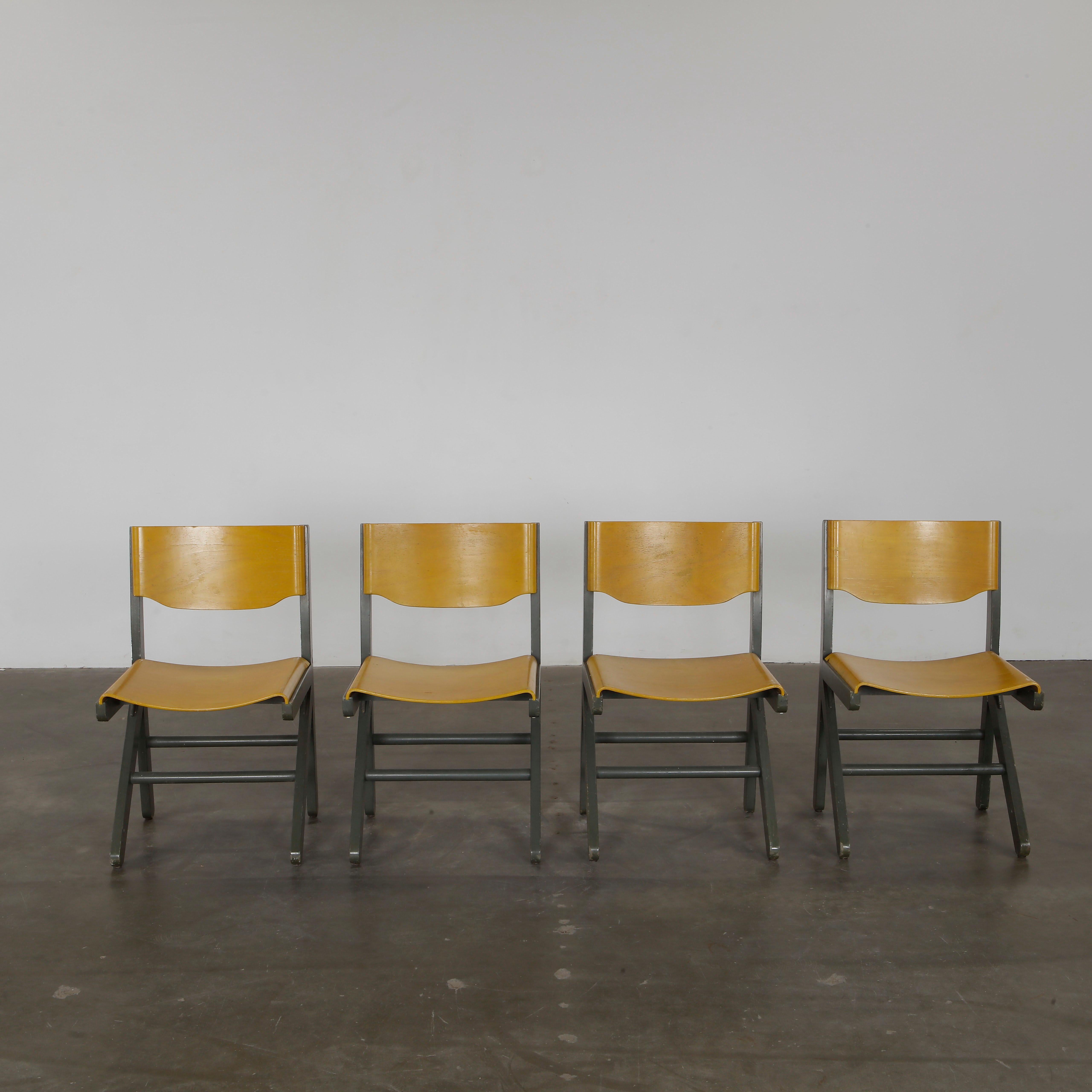 Elegant Koka chairs with curved yellow wood seats and grey tubular frames, blending modernist style with French craftsmanship. Height: 31 in. Width: 18.5 in. Depth: 17 in. Seat Depth 16 in.  Seat Height: 17.5 in.