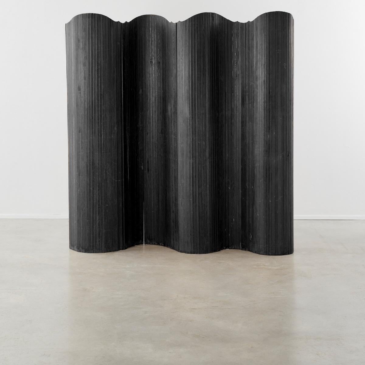 This twentieth-century Art Deco screen strongly recalls the hand of French designer Jomain Baumann. Its pine slats are stained and polished, and the flexibility of the joints – which are capable of unfurling in several configurations – is made