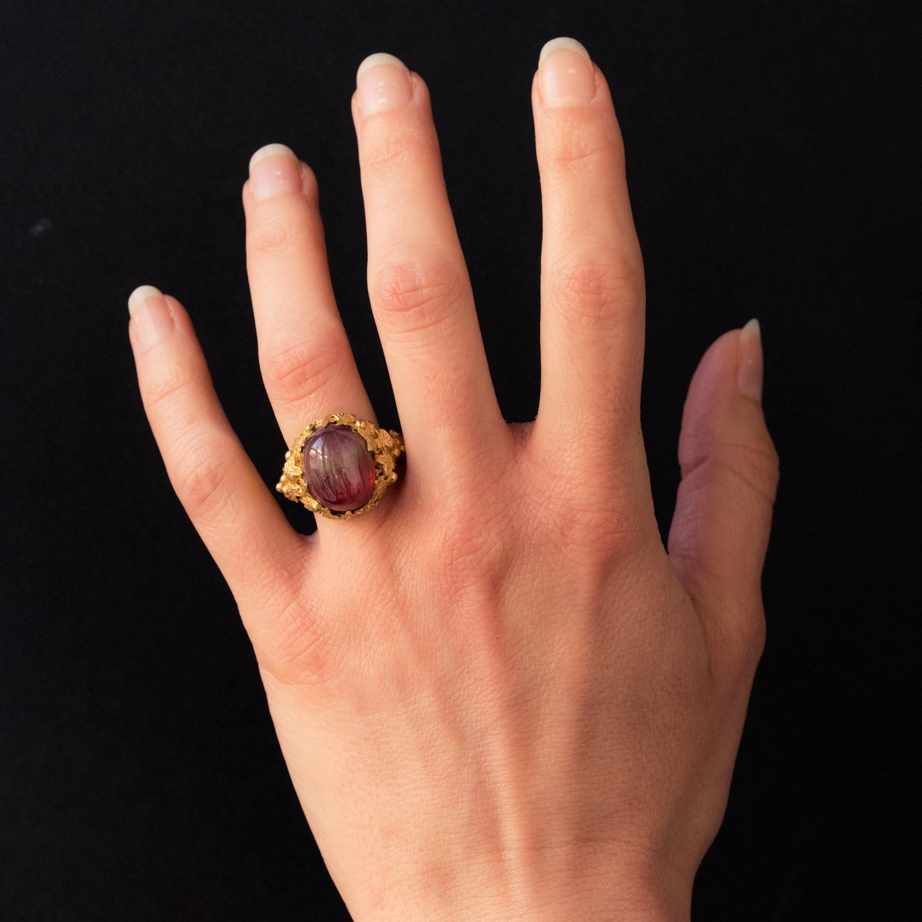 Baume Kreation - Einzelstück.
Ring aus 18 Karat Gelbgold.
Dieser Ring ist mit einem schönen Himbeer-Wassermelonen-Turmalin-Cabochon besetzt. Das strukturierte Ringband aus Gelbgold mündet in verschlungene Efeuzweige, die eine reizvolle Fassung für
