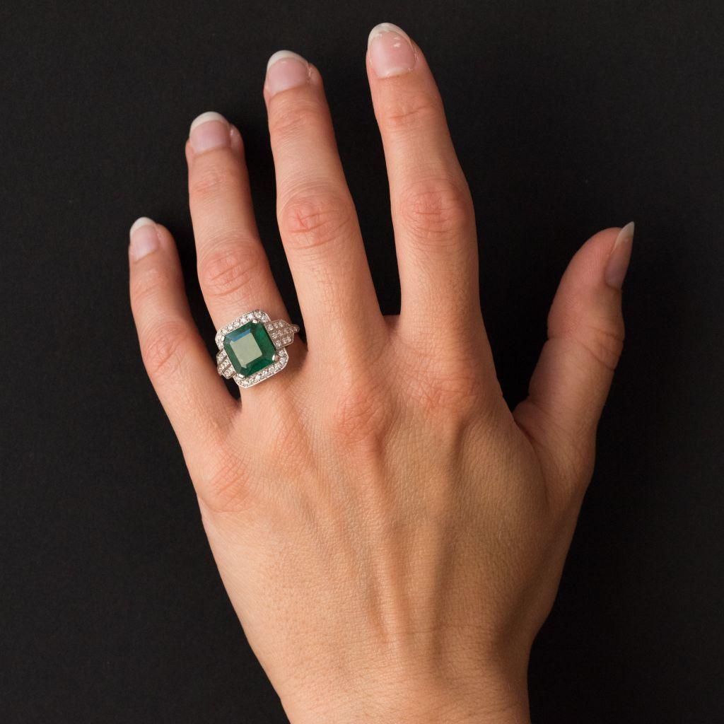 Creation Baume - Unique piece.
Ring in 18 karats white gold, head of eagle hallmark.
This splendid jewelery ring is set on its top with 4 flat claws of an emerald-cut emerald on a gem-set decor set with modern brilliant-cut diamonds. The start of