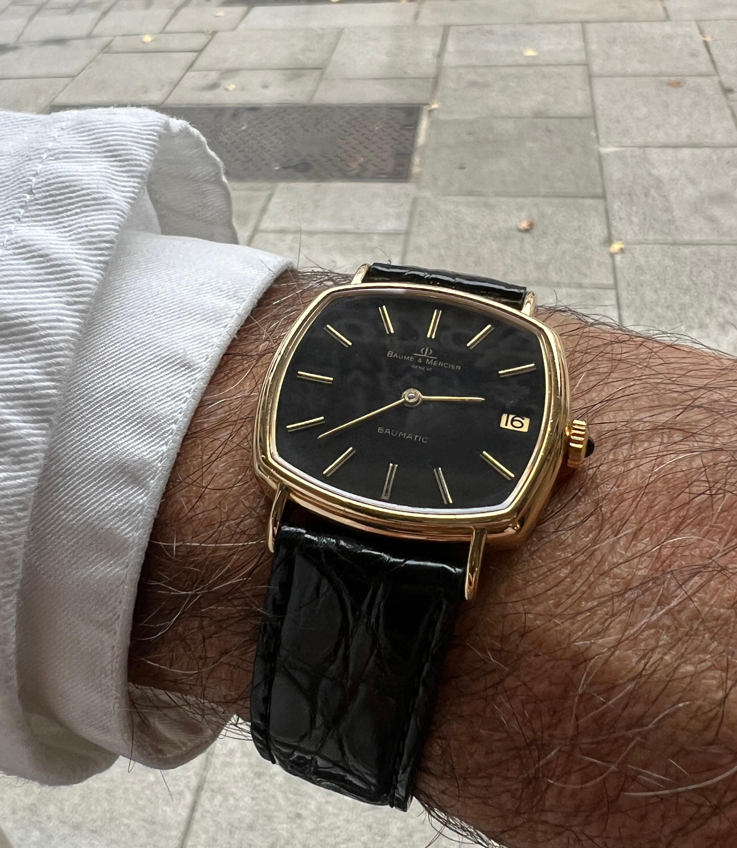 Baume et Mercier Yellow Gold 18 Carats Black Leather Strap Cushion Watch


- Brand: Baume & Mercier  
- Model: Cushion  
- Material: Solid 18K Yellow Gold  
  - Gold Weight: 23.14 grams  
- Movement: Automatic  
  - Caliber: Baumatic 12820 with
