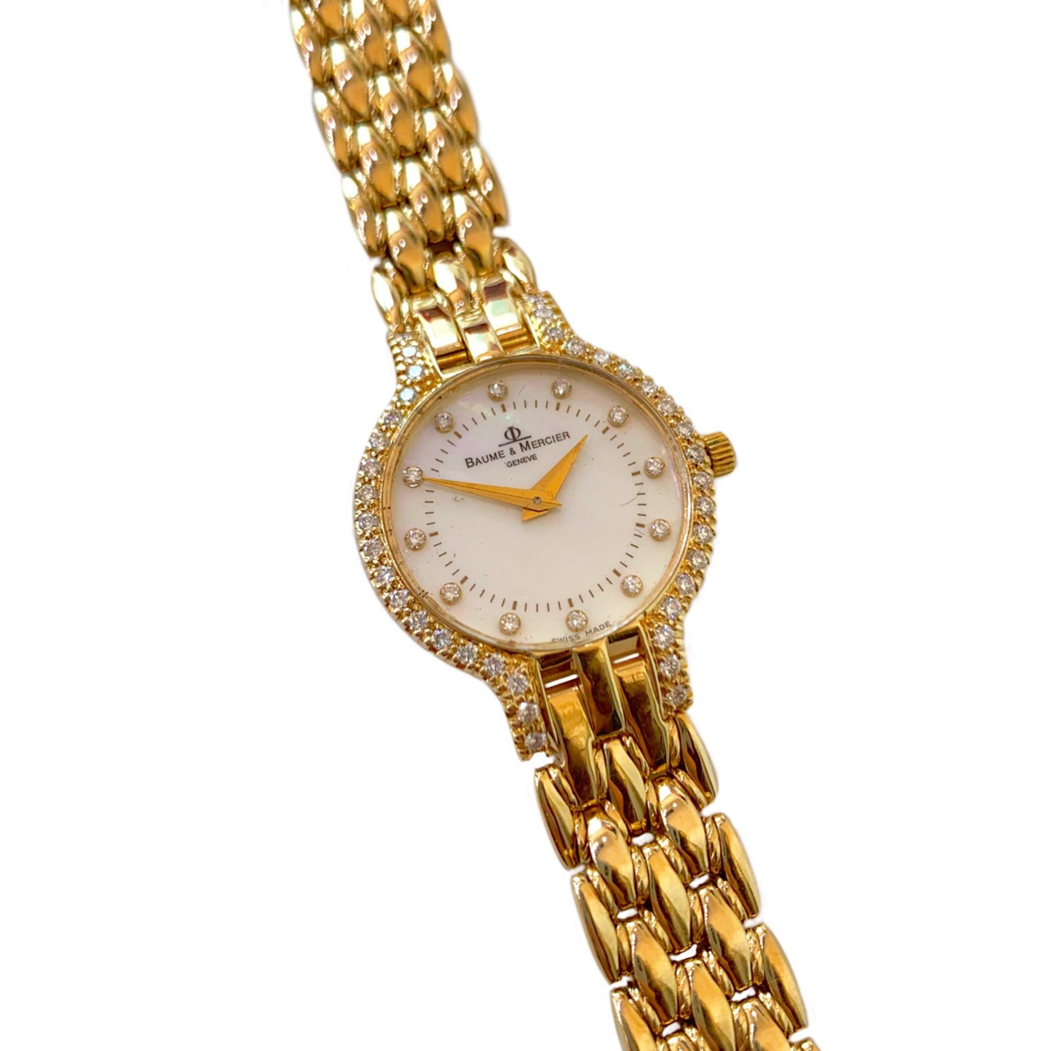 Classic Baume & Mercier 14 karat yellow gold diamond watch. The mother of pearl dial has diamond markers and is enclosed in a diamond case with a total weight of approximately .75 carats. The Swiss quartz movement is contained in a 24 mm head, which