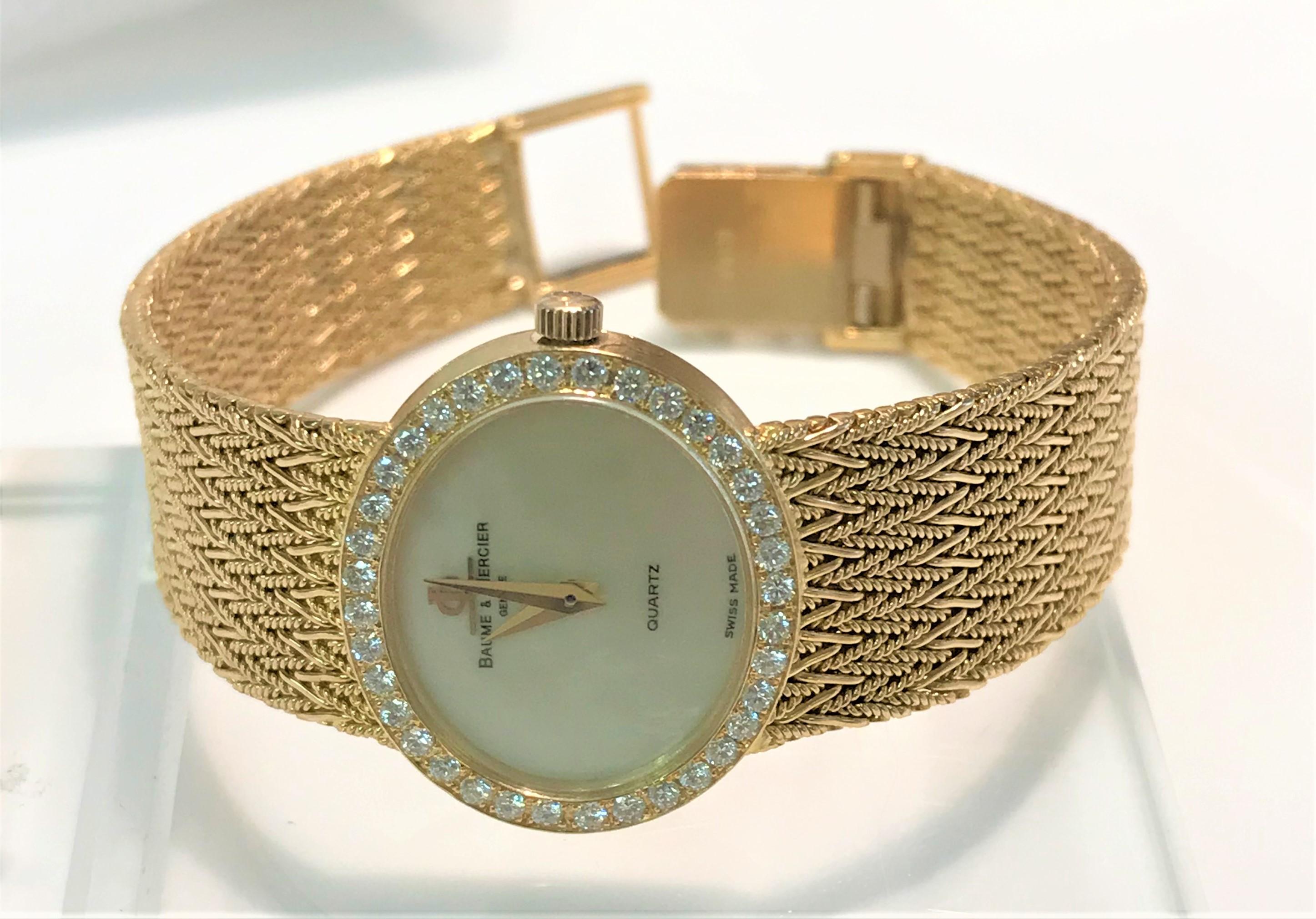 By luxury brand Baume & Mercier, this beautiful watch is a timeless statement piece!
18 karat yellow band and case
Mother of pearl, oval face surrounded by 36 round diamonds
     Approximately 25mm wide (including stem)
     Approximately 20mm high

