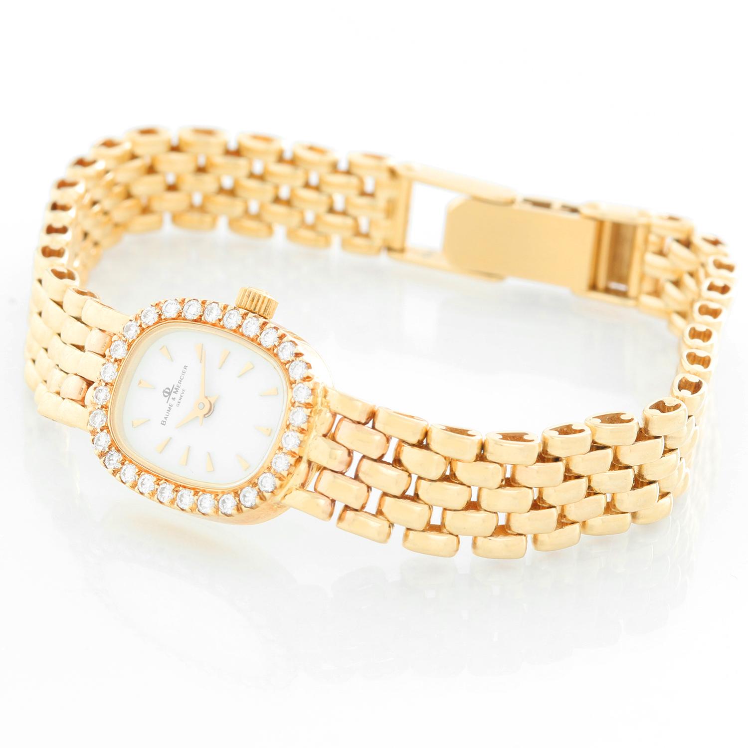 Baume & Mercier 18K Yellow Gold Diamond Watch - Quartz. 18K Yellow gold with diamonds on bezel ( 24 mm ). White dial with raised gold Roman numerals. 18K Yellow gold link bracelet; Will fit a 7 inch wrist . Pre-owned with custom box.