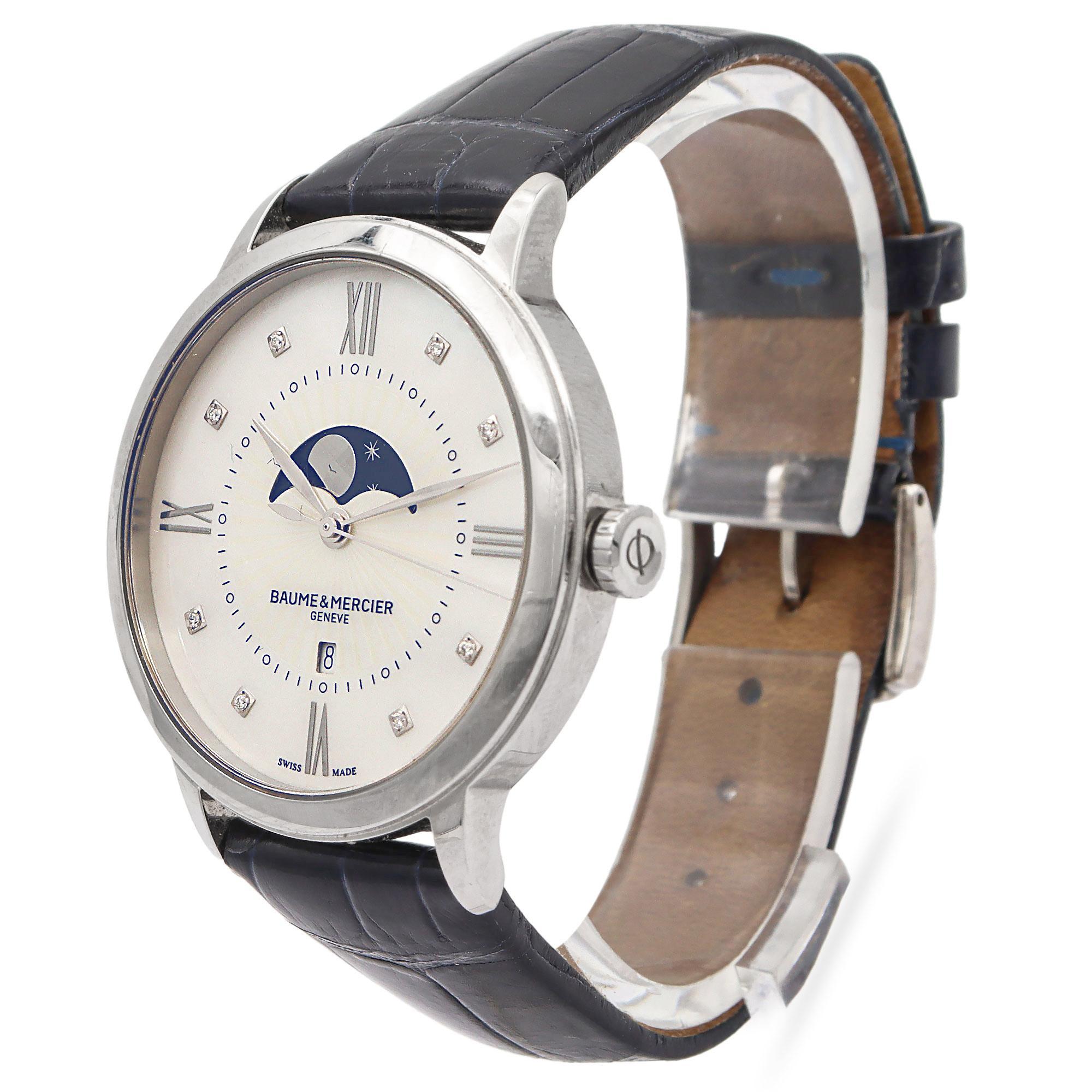 This elegant Baume & Mercier wristwatch is a refined expression of classic Swiss craftsmanship and sophisticated design. The polished stainless steel case frames a stunning mother-of-pearl dial, beautifully accented with diamond hour markers and