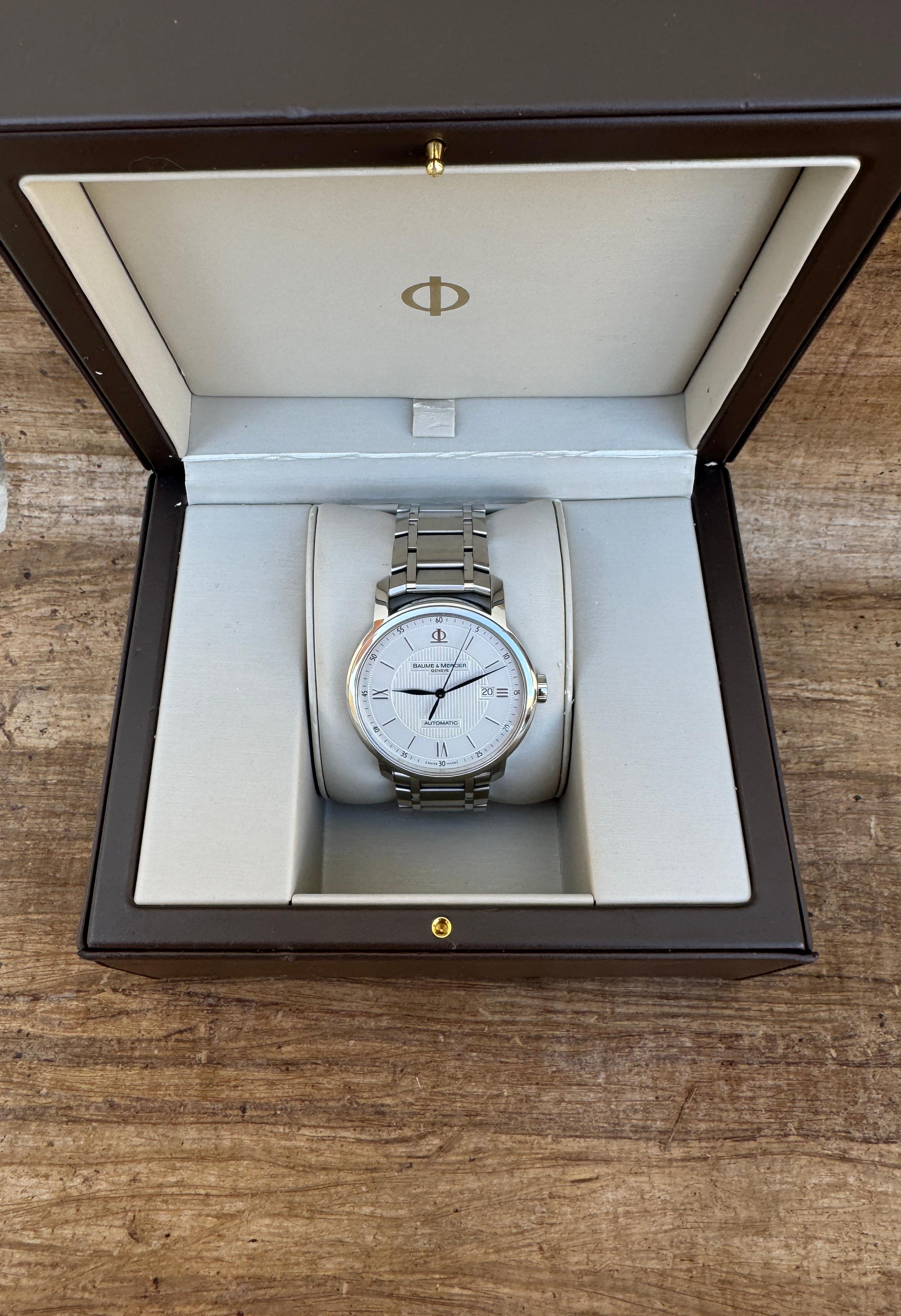  Descrizione
Marchio: Baume & Mercier

Model: Classima Executive

Riferimento: 65593

Paese di produzione: Svizzera

Movimento: Automatico

Materiale della cassa: Acciaio inossidabile

Misure : Larghezza della cassa: 42 mm. (senza corona)

Tipo di