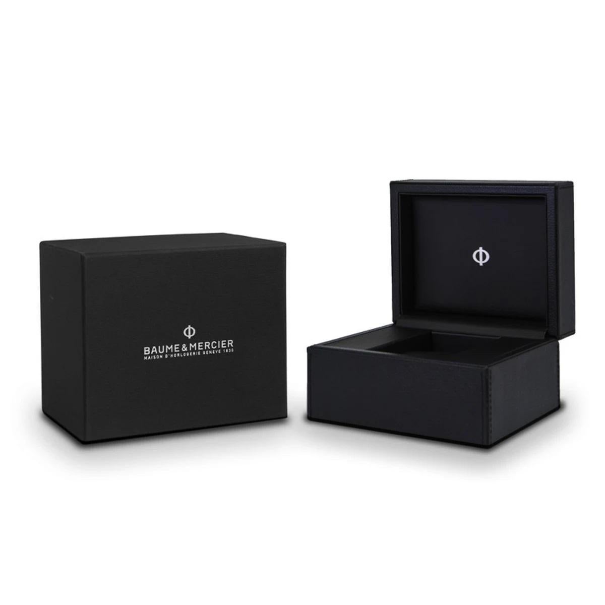 Este reloj de pulsera certificado por el COSC funciona con nuestro calibre automático de fabricación Baumatic. Tiene una esfera lacada burdeos con un retículo blanco en el centro y agujas e índices rodiados. Una clásica apertura de fecha a las 3 en