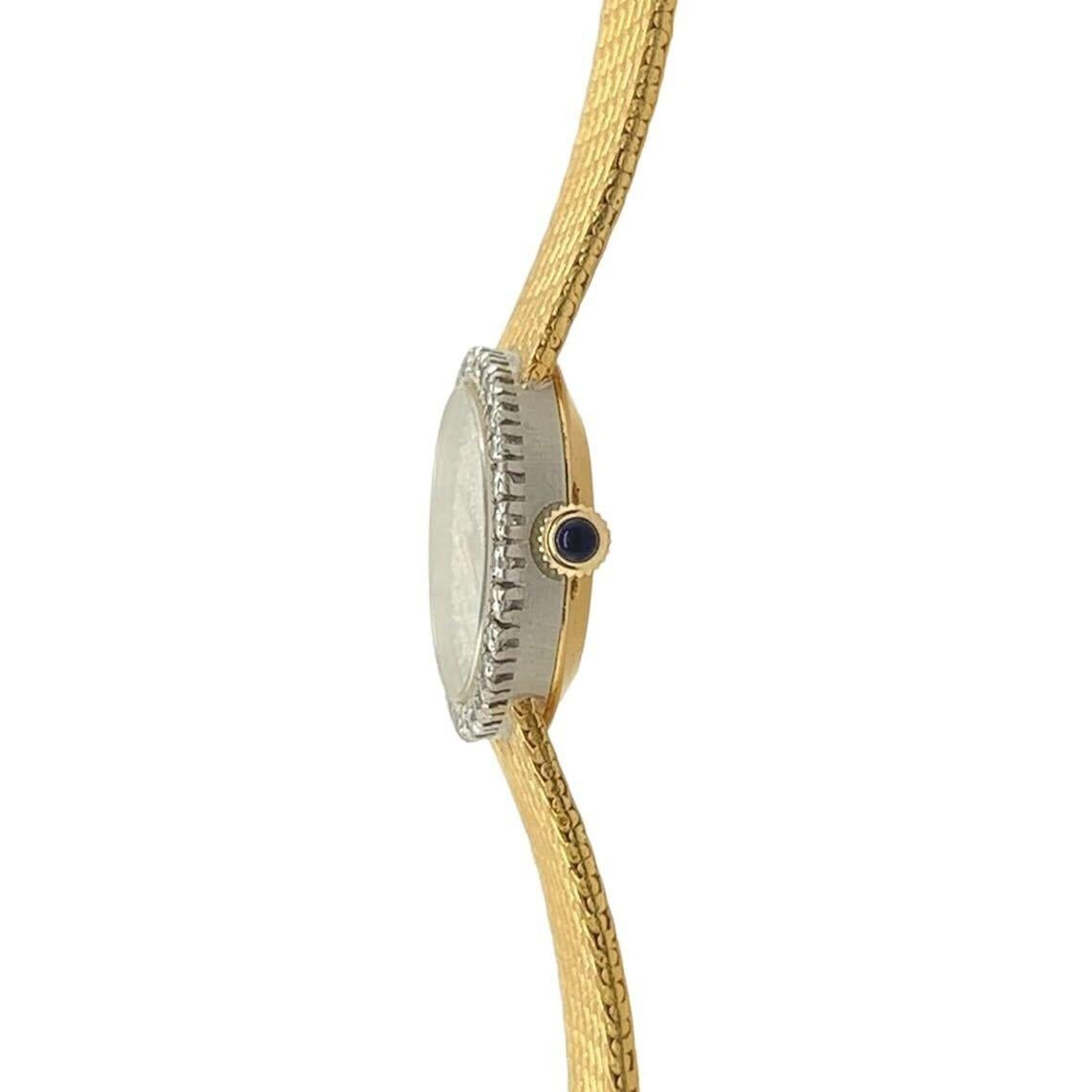 An 18 karat yellow gold, platinum and diamond watch, Baume & Mercier.  The manual movement watch designed as a horizontal oval dial of platinum pave set with approximately seventy five (75) round brilliant cut diamonds completed by gold hands within