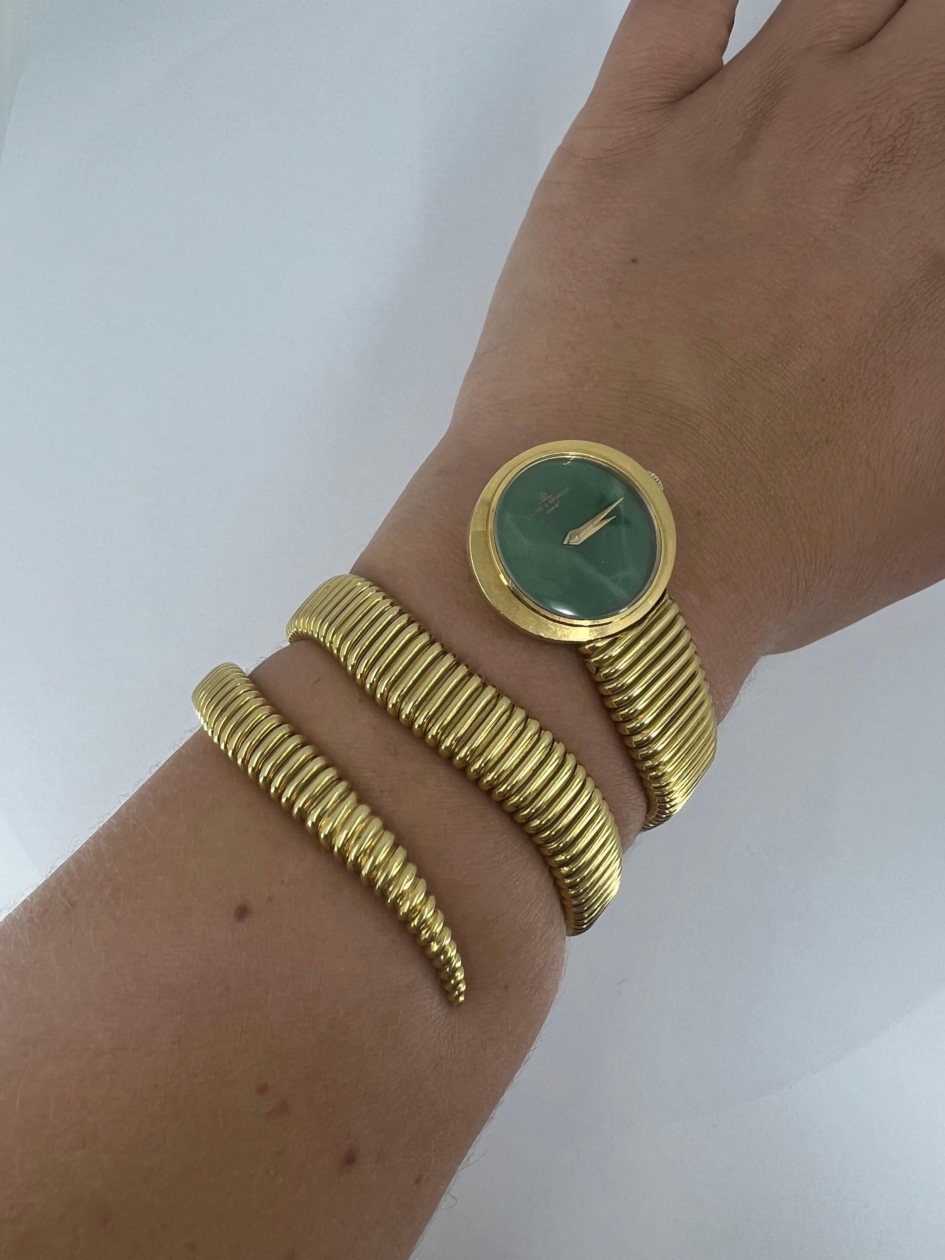A luxurious timepiece by Baume et Mercier. The watch is made of 18k gold, features a malachite face.

The watch’s bracelet of Tubogas design with slightly wavy lines looks very feminine. It’s flat and refined, which works great with the elliptical