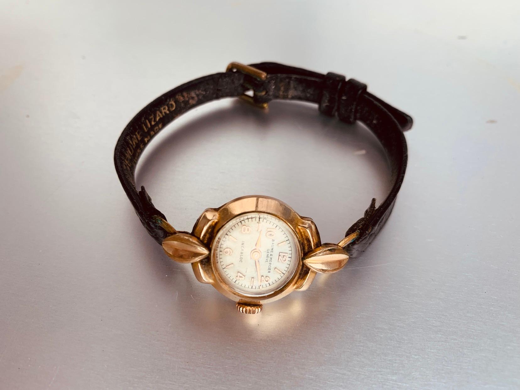 Baume & Mercier ladies gold lizard strap hand watch.