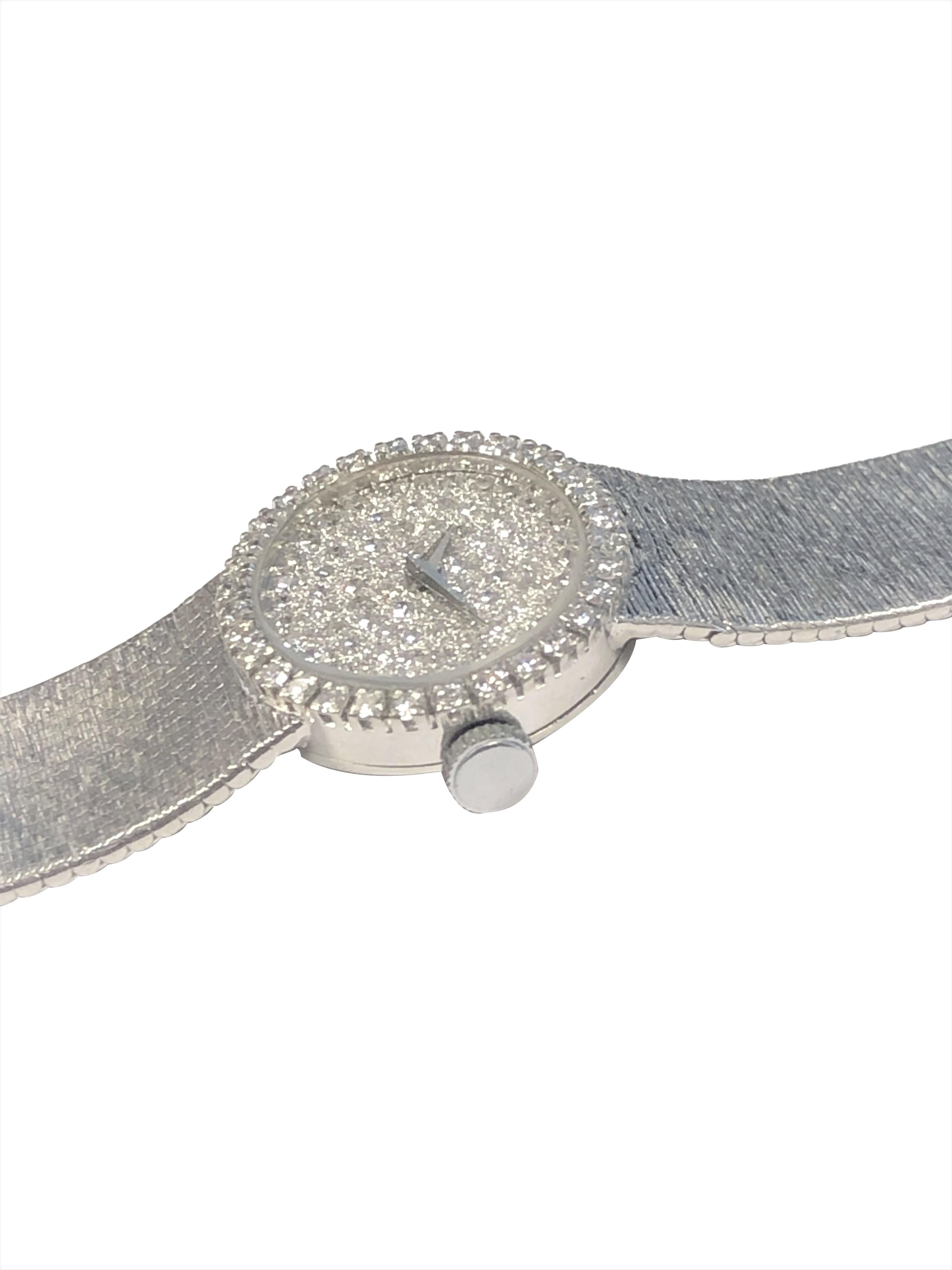 Circa 1970 Baume & Mercier Ladies Wrist Watch, 25 X 22 M.M 18K White Gold 2 Piece case with Diamond set Bezel. 17 Jewel mechanical, Manual wind movement. Diamond Pave Dial. Total Diamond weight for the watch is 2 Carats. 5/8 inch wide soft textured