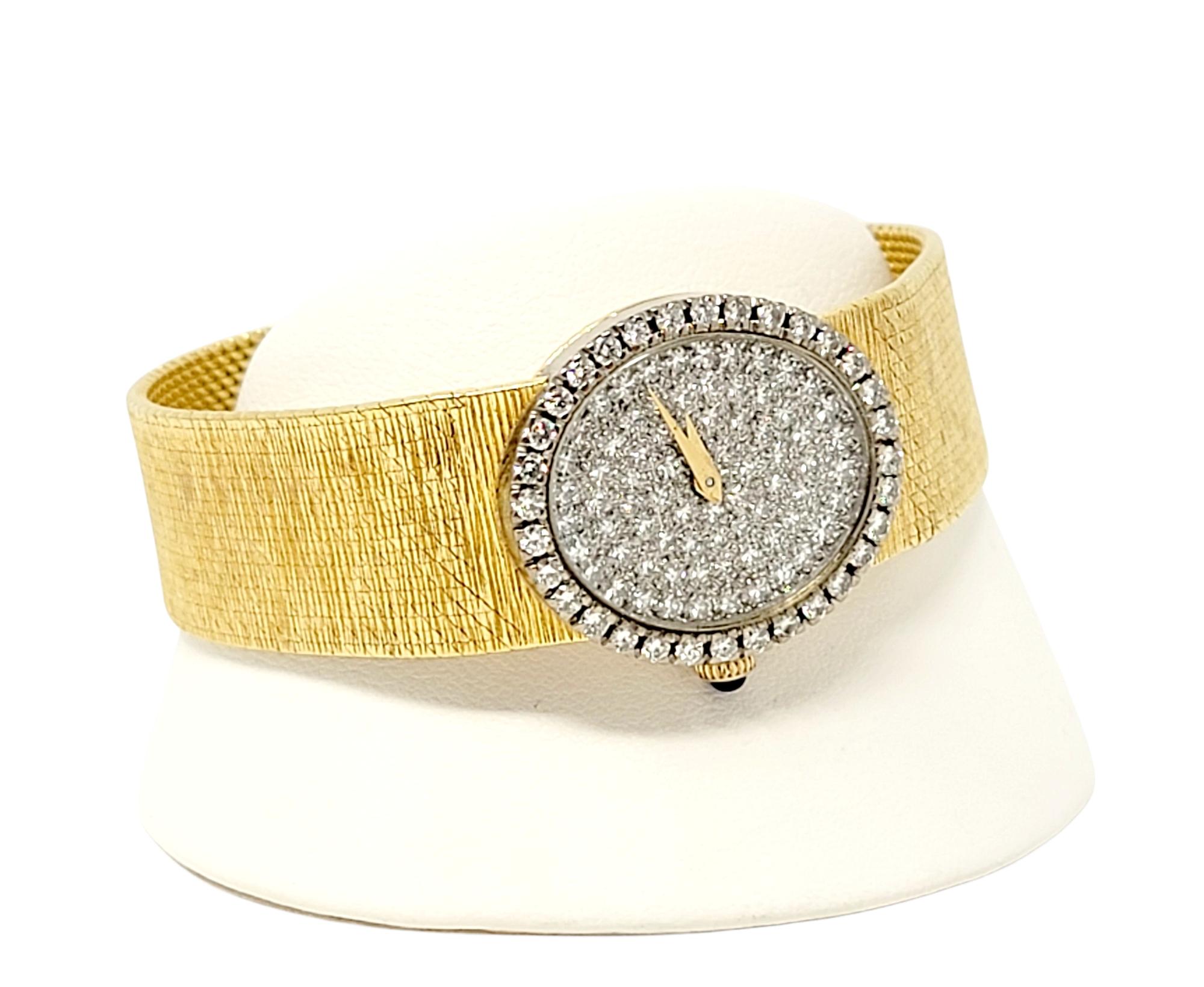 Luxurious vintage Baume & Mercier ladies wristwatch embellished with 1.28 carats of glittering natural diamonds. The flexible textured 18 karat yellow gold bracelet gently wraps the wrist while the sparkling diamond embellished dial shimmers and